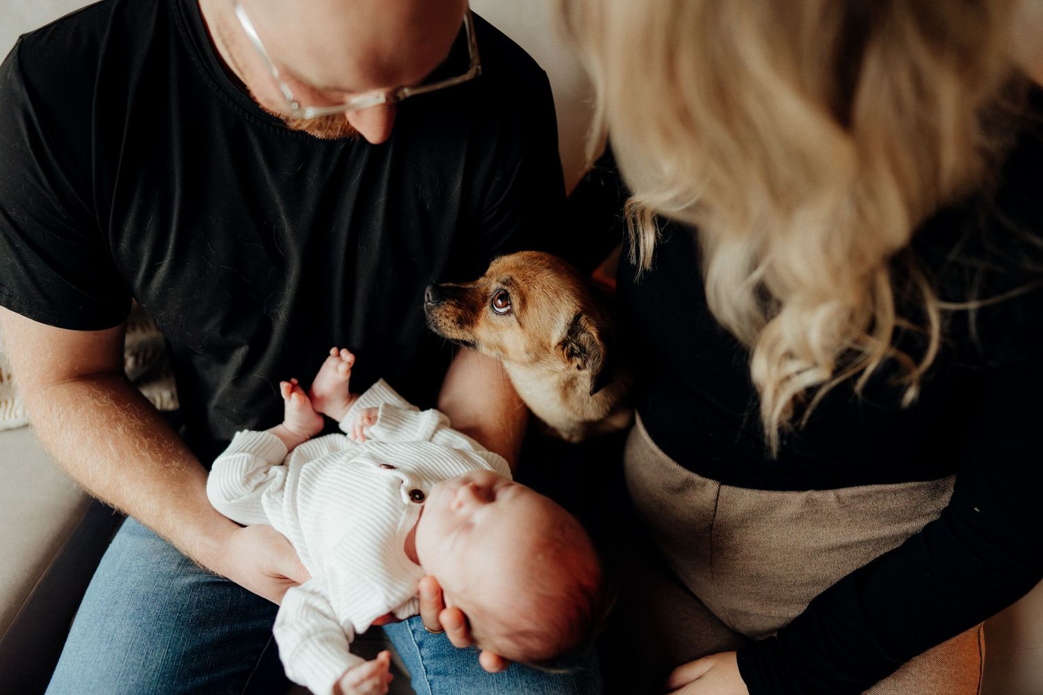 Artistic black and white capture of family bonding with newborn at home.