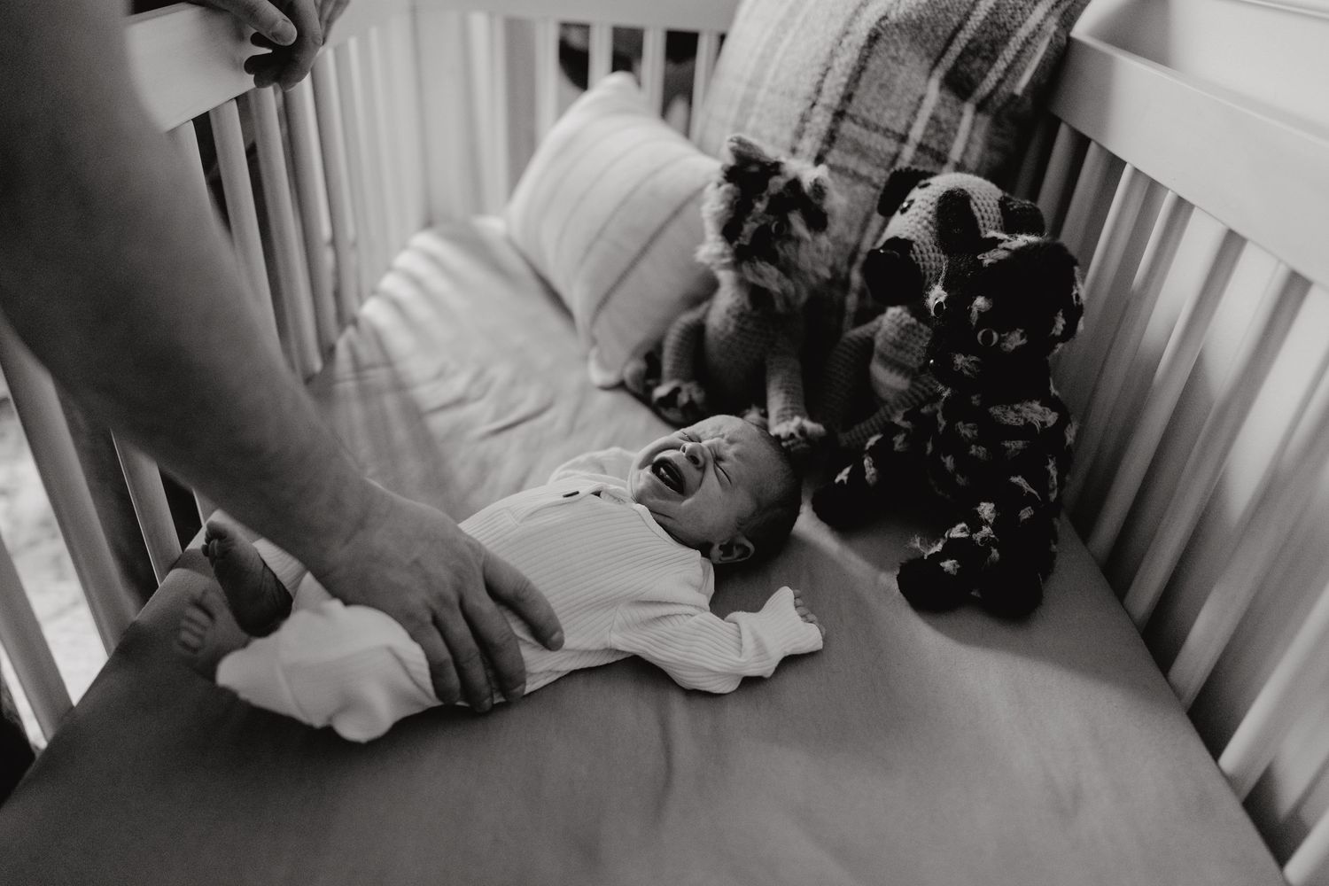 A cozy nursery scene with an infant resting in a white crib.
