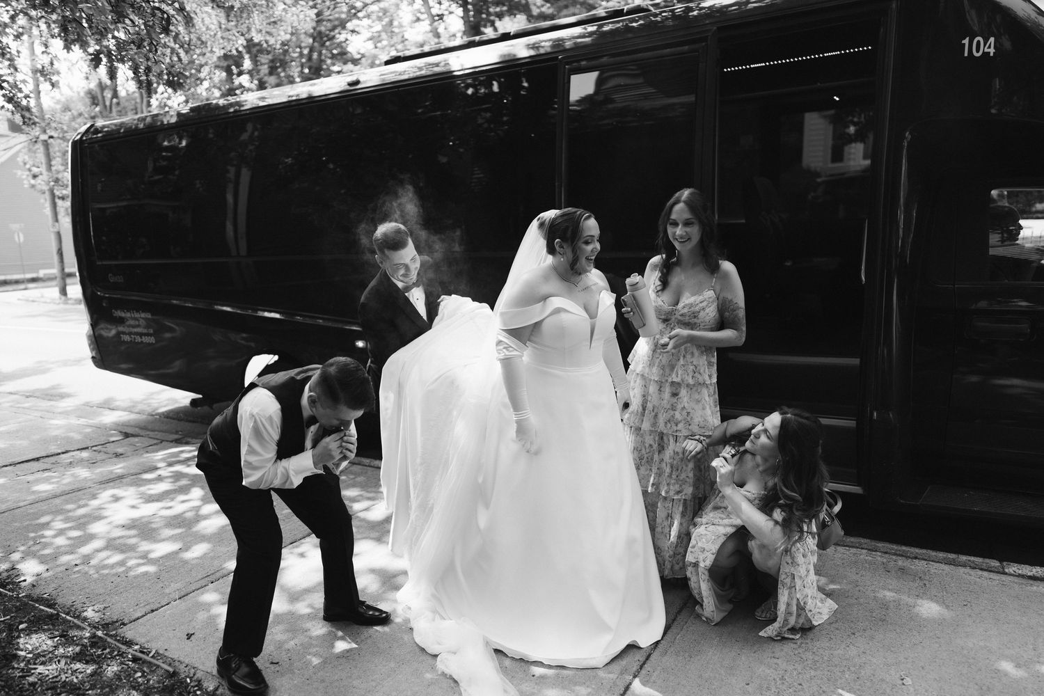 Black and white photo of newlyweds walking together along a path.