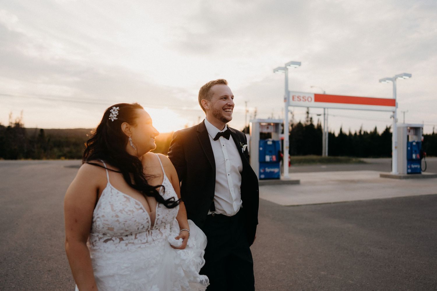 Wedding couple sharing intimate moments in front of a gas station at golden hour.