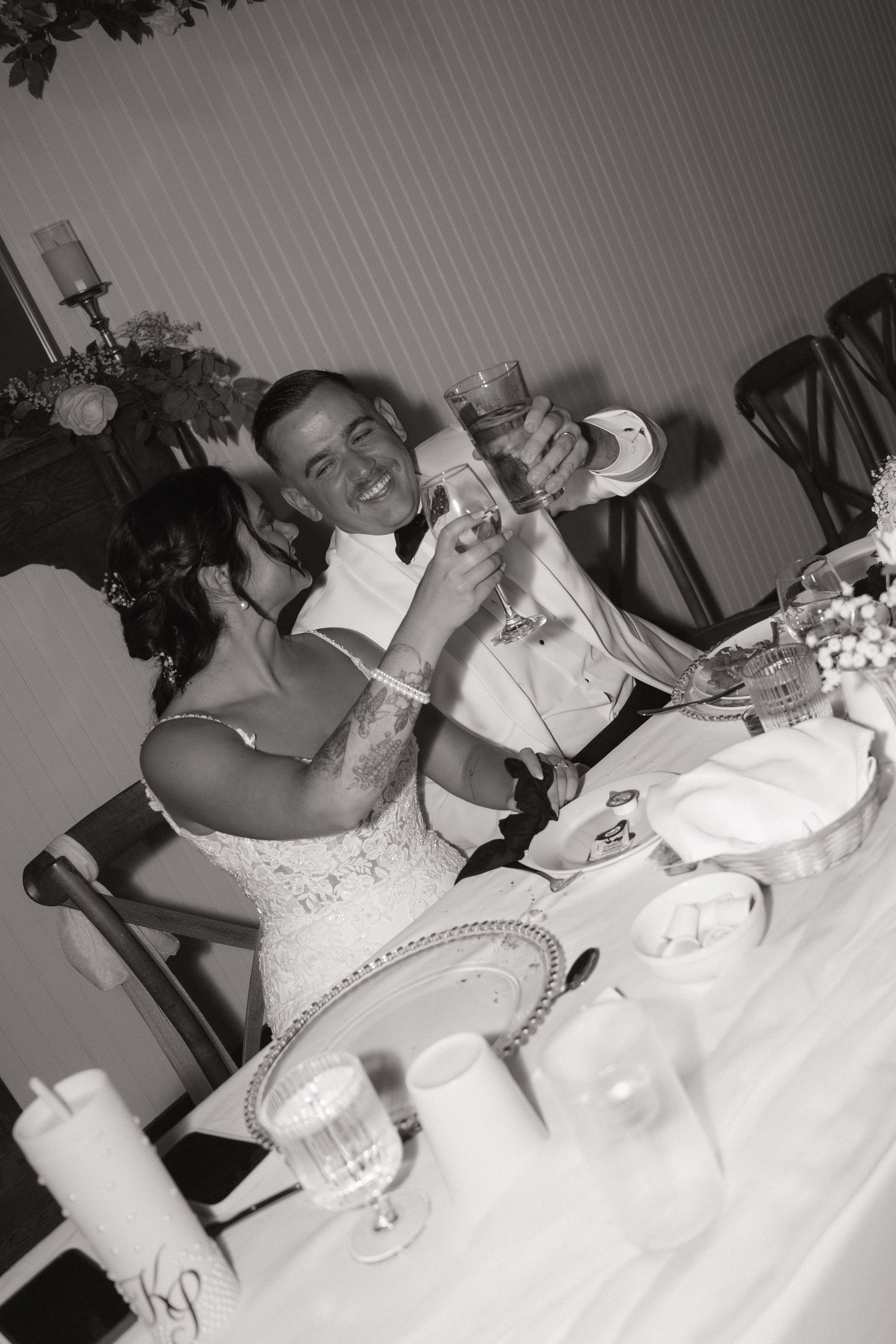 A series of black and white photos showing a wedding couple sharing champagne and cake at their reception.