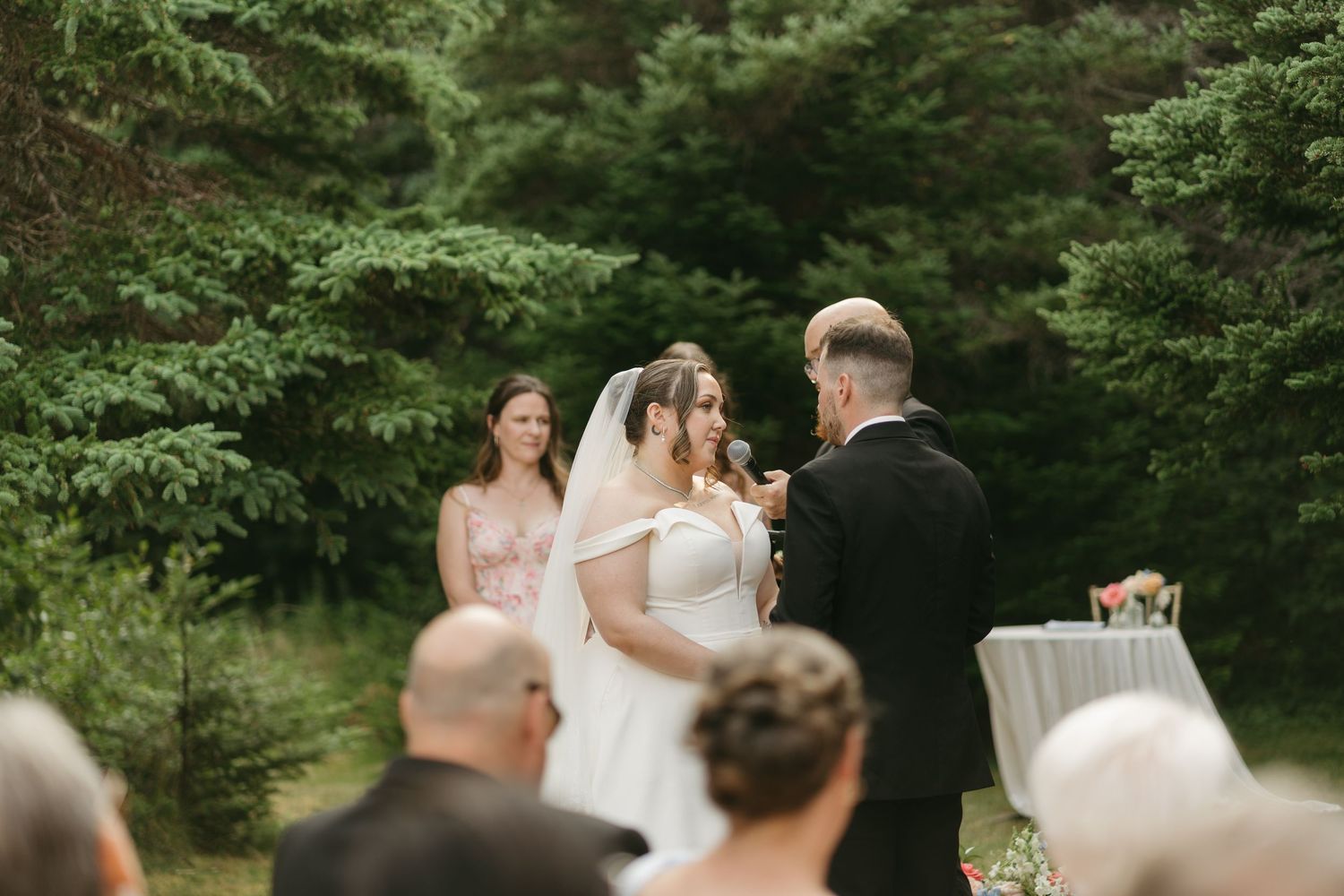 Candid wedding ceremony moments photographed against a backdrop of evergreen trees.