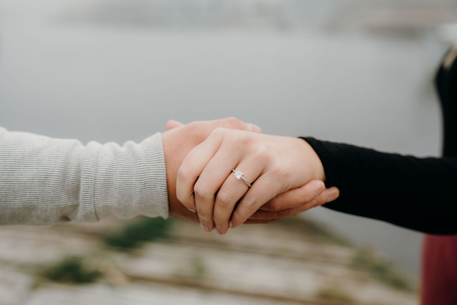 Close-up detail shot of hands holding together intimately by the beach.