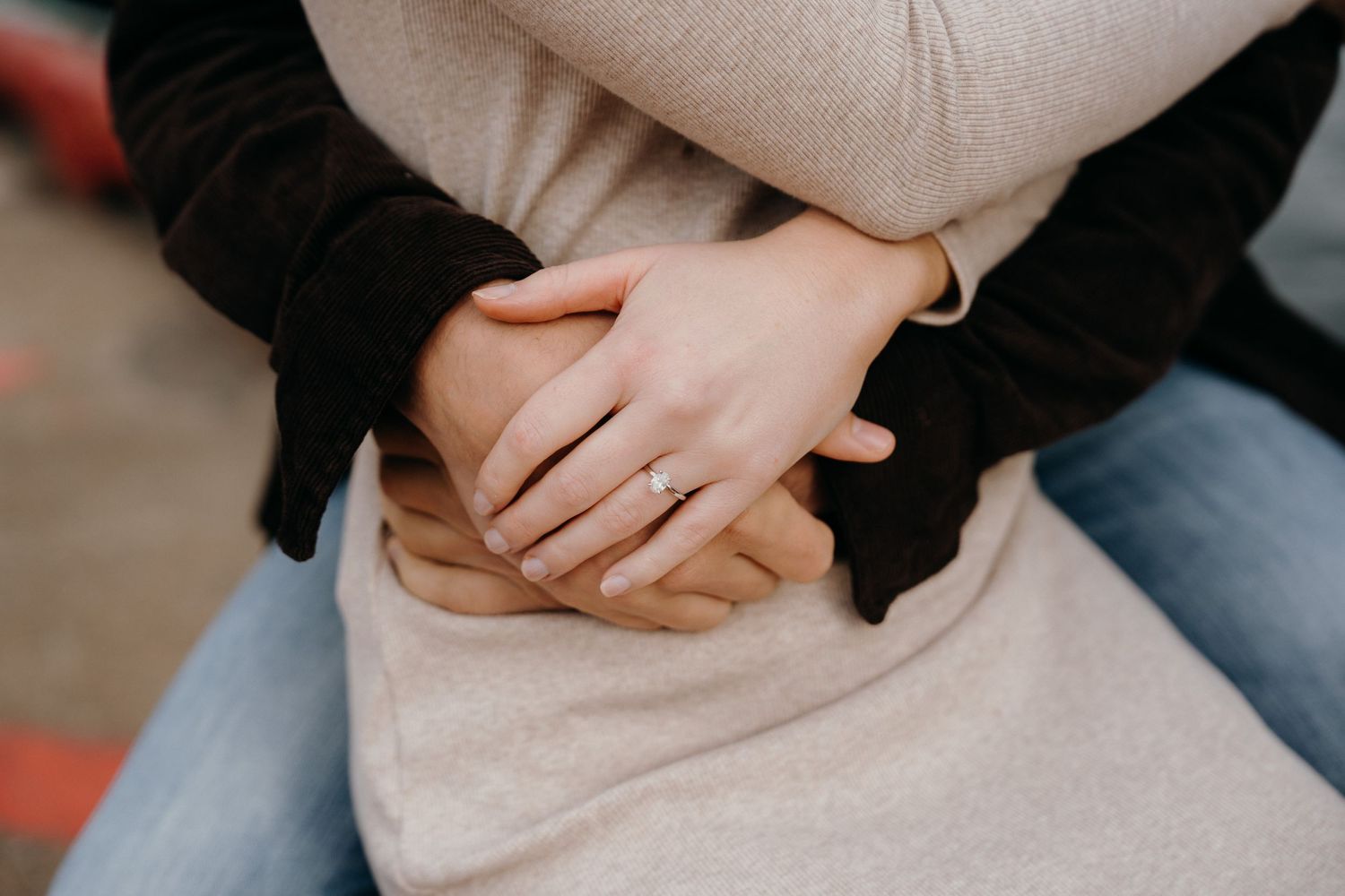 Intimate detail shot of hands resting against casual clothing.
