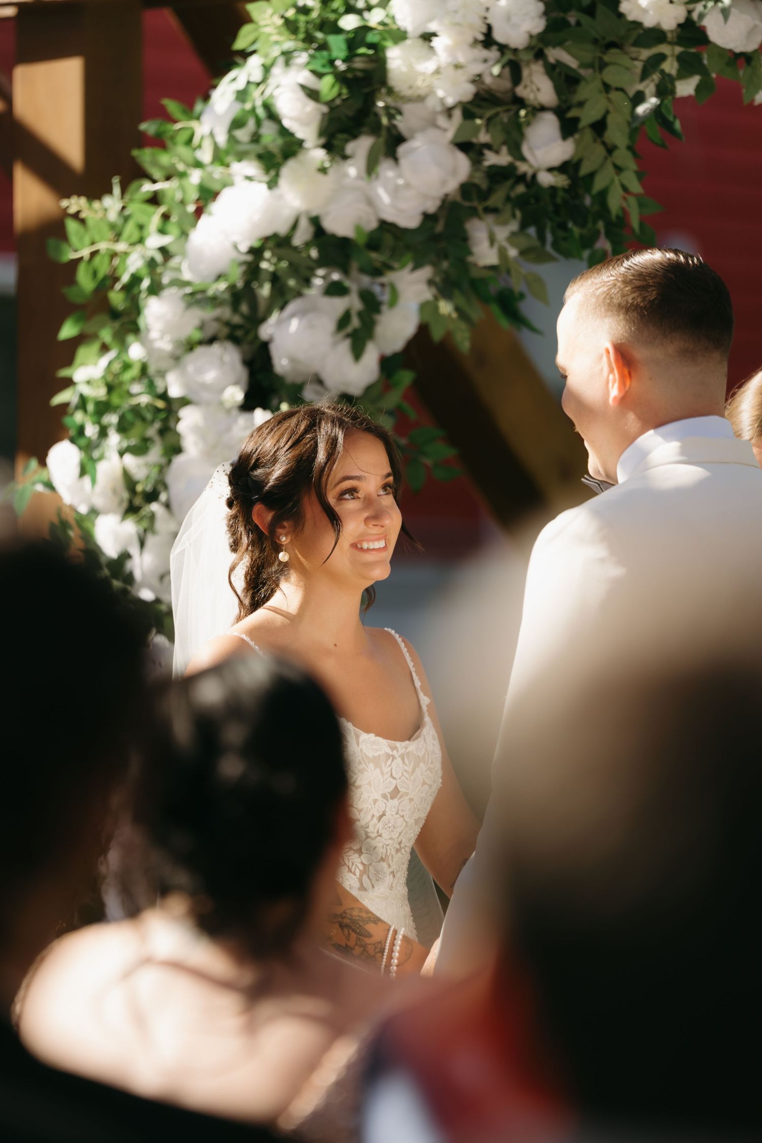 A romantic wedding scene with white floral decorations and soft natural lighting creating an intimate atmosphere.