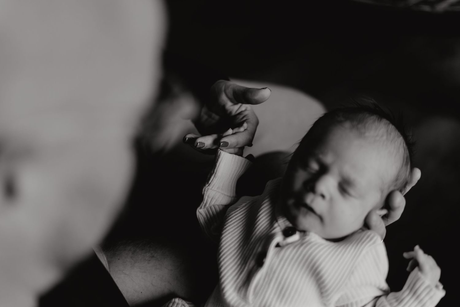 Black and white photograph capturing a peaceful home moment with family members relaxing together.