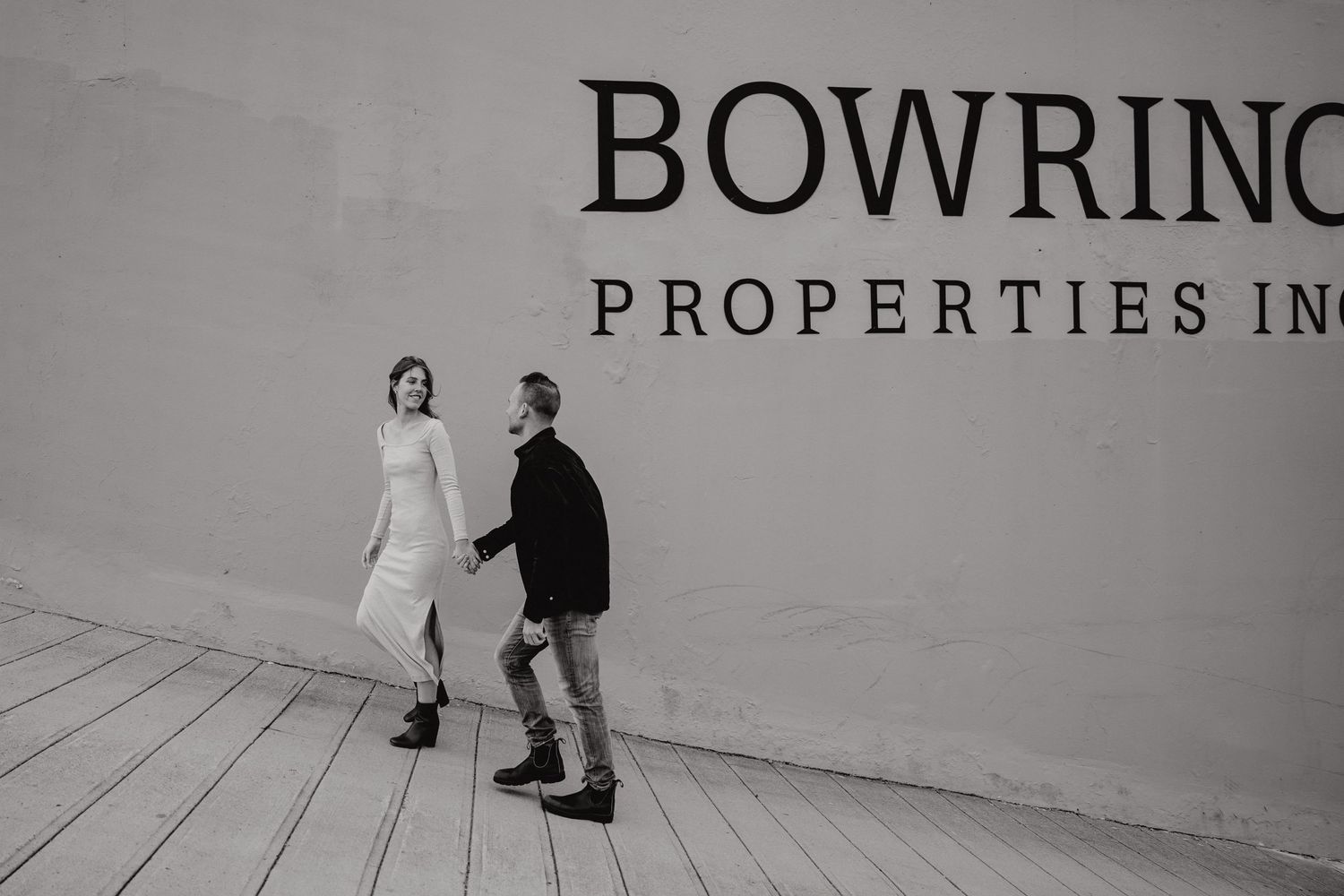 Two people walking together along a modern building exterior with corporate signage.