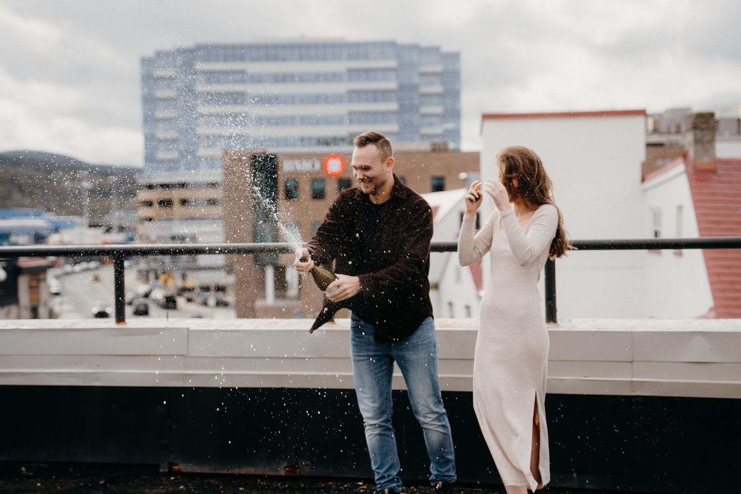 An intimate rooftop scene shows two people in what appears to be a proposal moment.