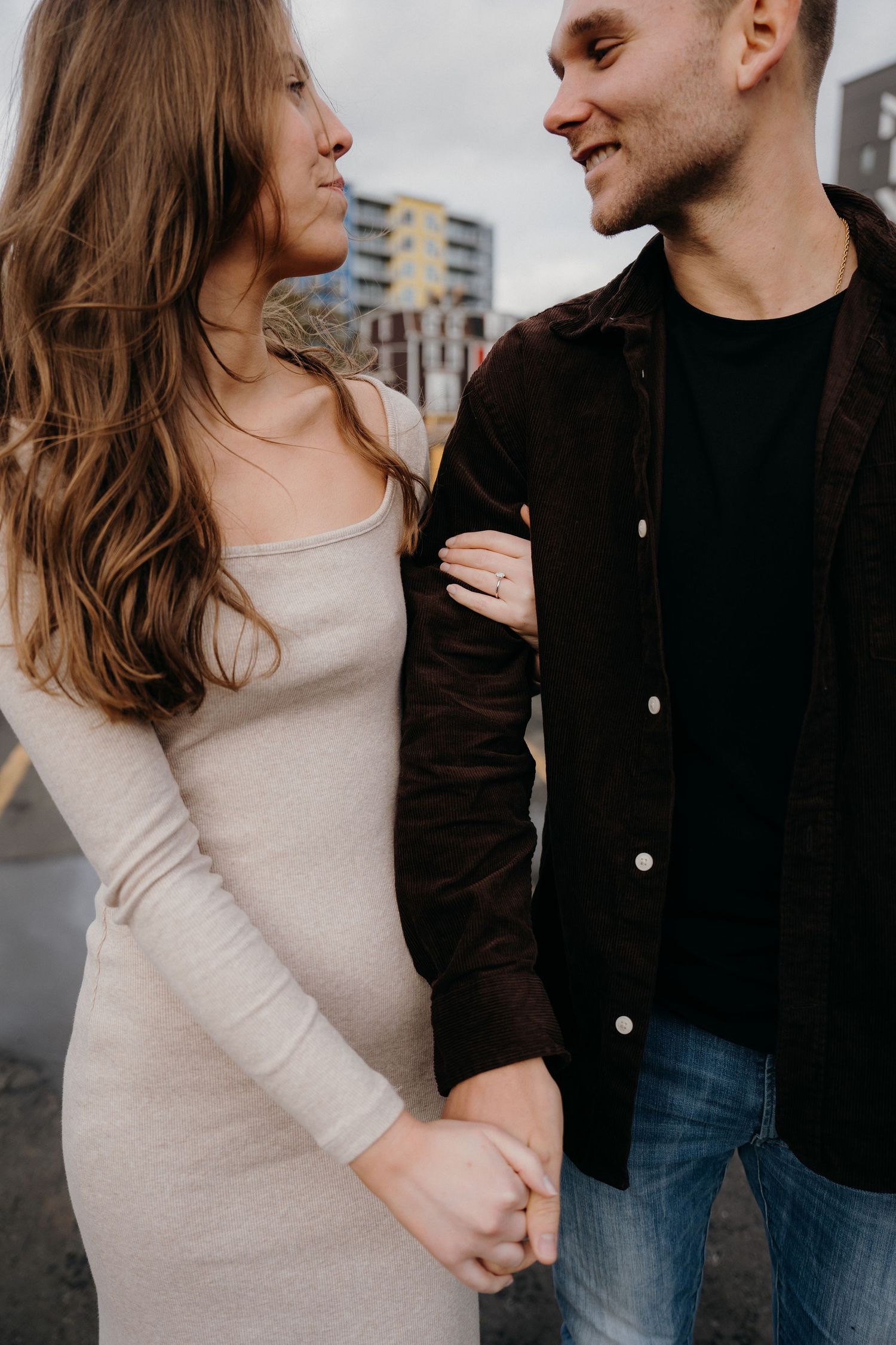 Close-up of a couple in contrasting outfits - cream sweater and black jacket - sharing a tender moment.