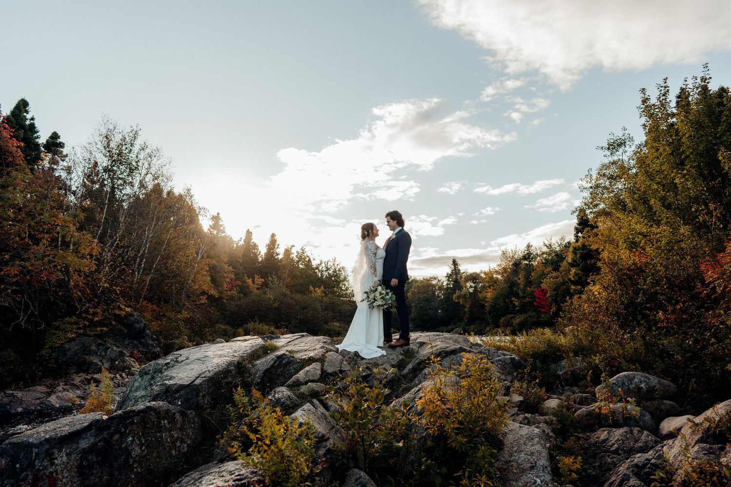 Scenic mountainside with silhouettes against a dramatic sunset sky.