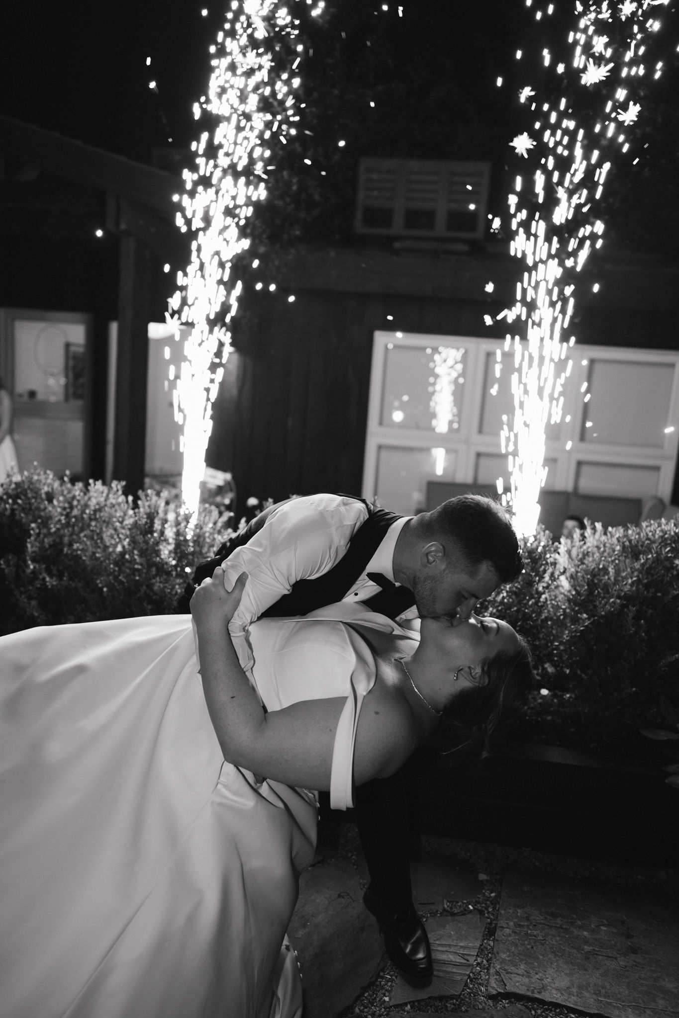 A romantic nighttime kiss with sparklers creating a magical backdrop.