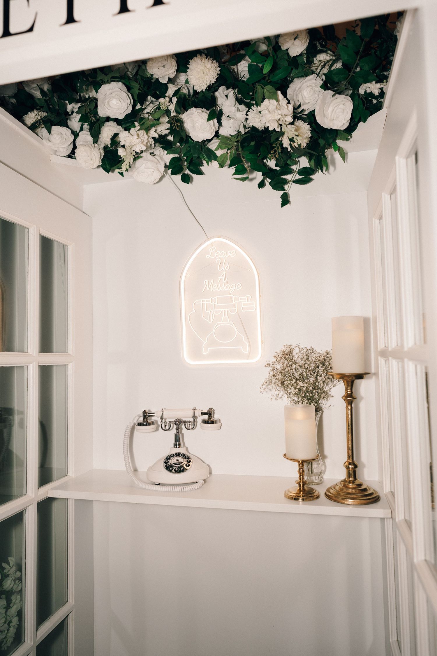 Elegant white wedding venue decor with floral arrangements and candlesticks creating a romantic ambiance.