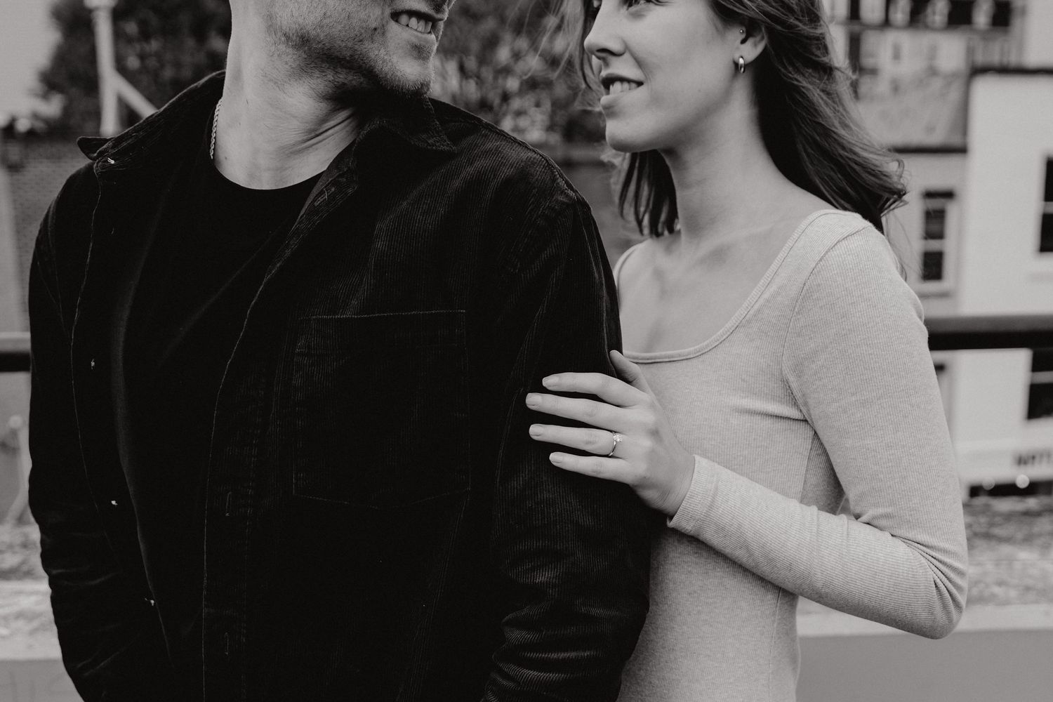 Sweet moment between couple on city rooftop during engagement photoshoot.