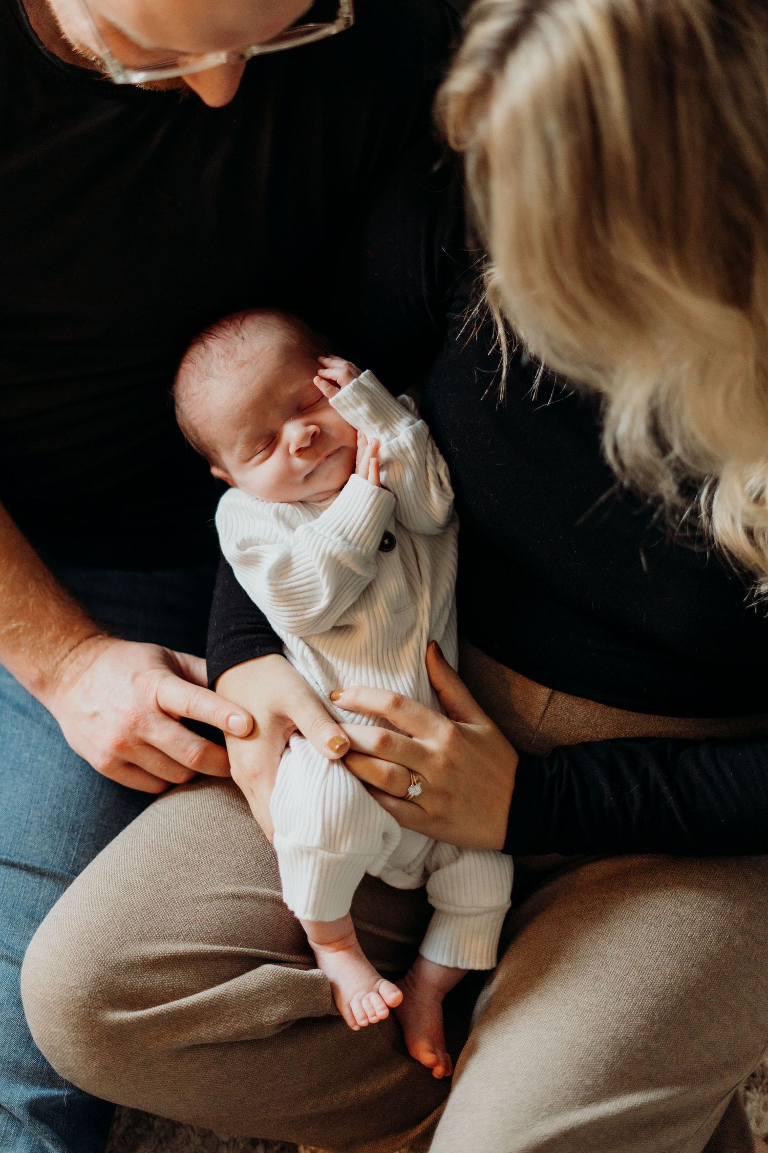 Series of intimate moments with infant in white onesie.