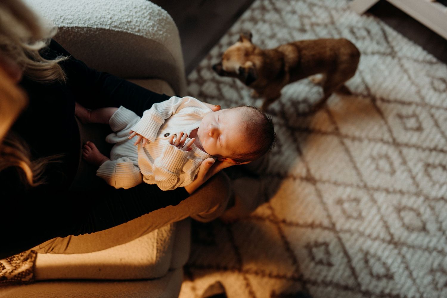 Moody overhead shot of infant on textured floor with diagonal lighting.
