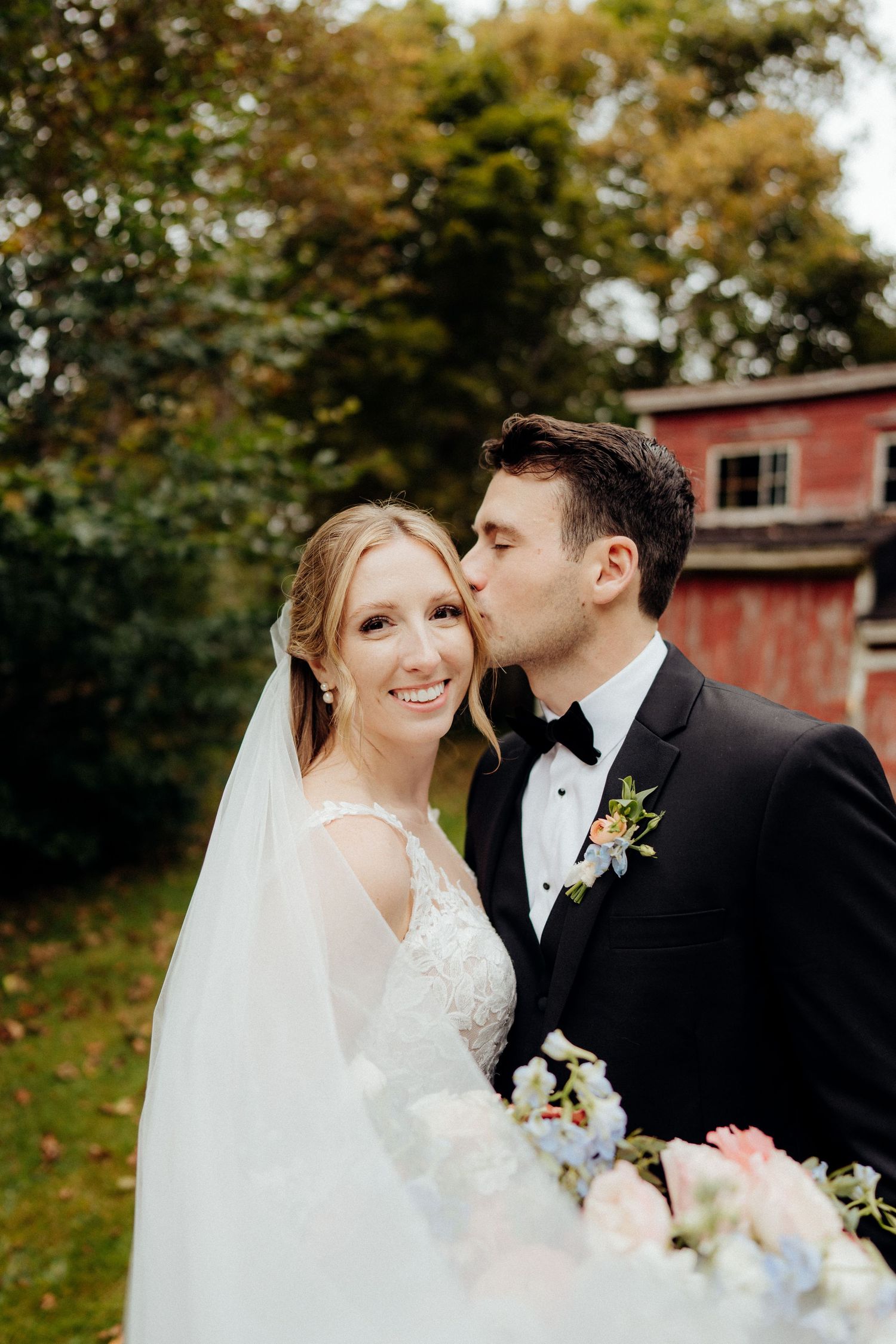 Romantic outdoor wedding scene with lush greenery and floral bouquet.