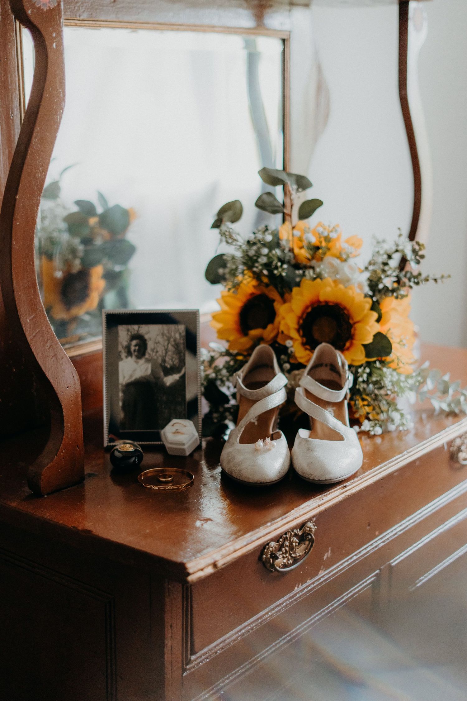 Rustic wedding decor featuring sunflowers and vintage teapots on wooden furniture.
