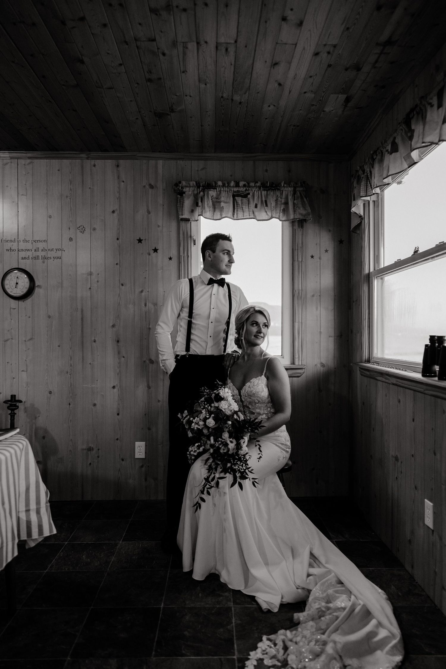 Intimate black and white wedding moments captured in rustic wood-paneled room.