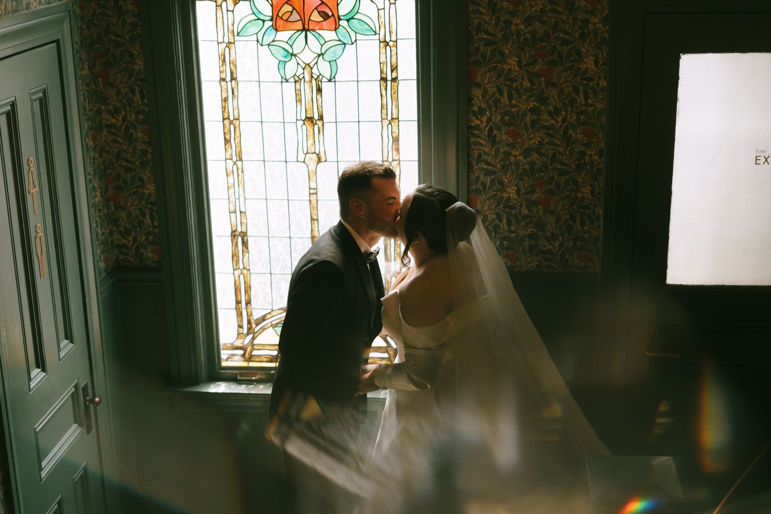 Romantic scene in a well-lit room with stained glass windows.