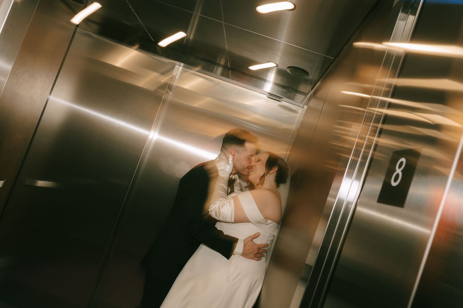 Artistic black and white wedding couple portraits taken in a modern elevator with dramatic lighting.
