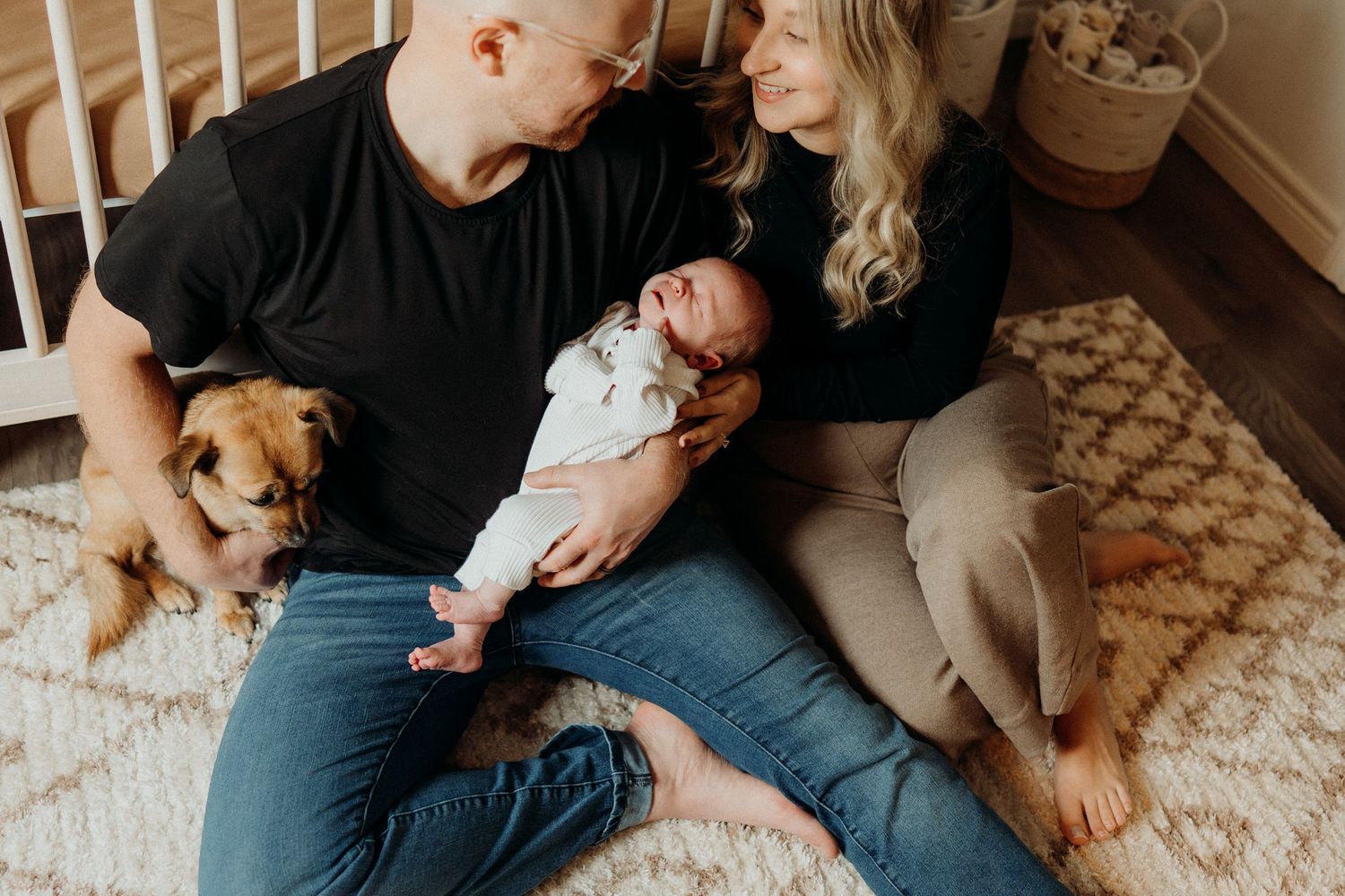 A warm family moment on a carpeted floor with a small Chihuahua mix dog joining in.