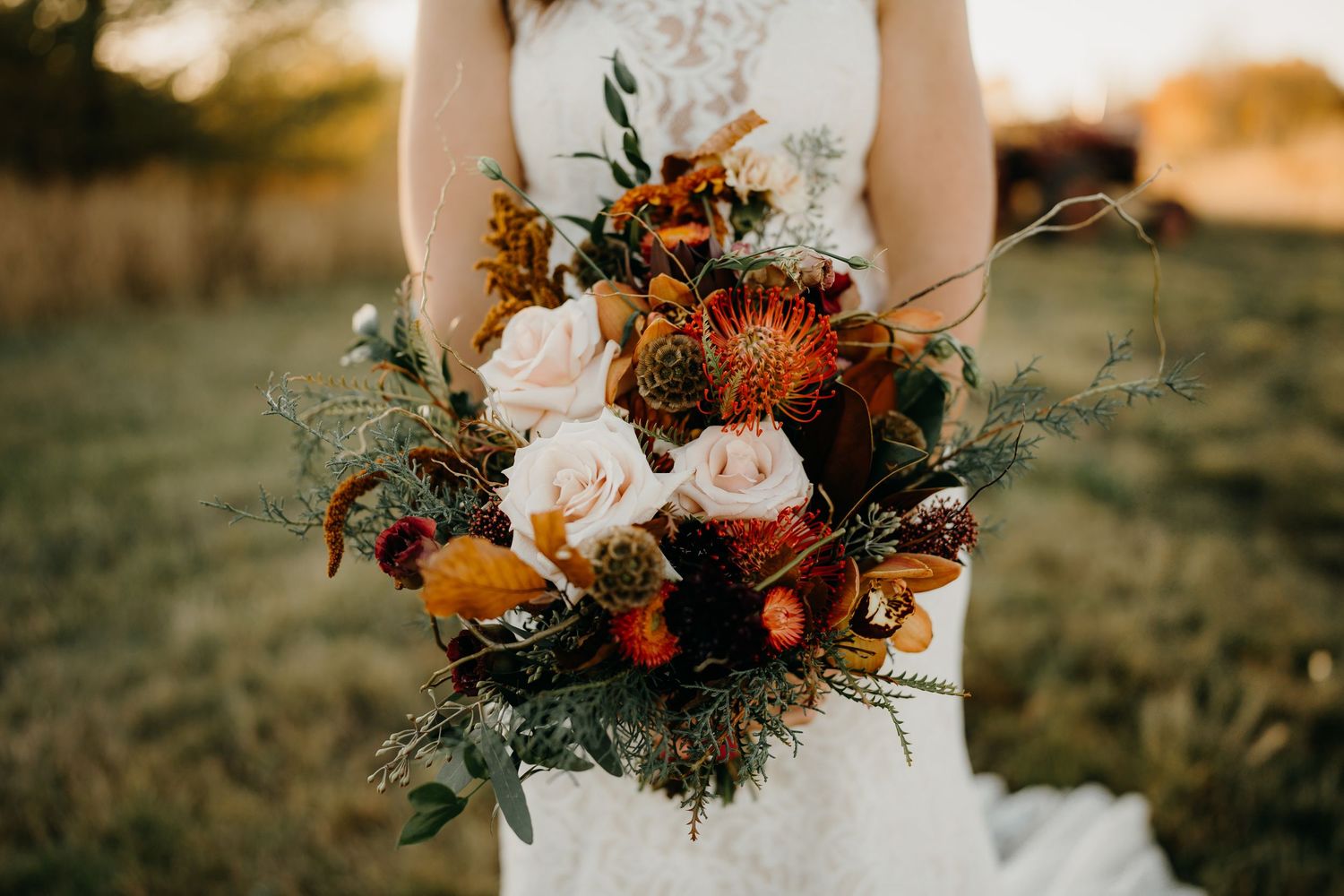 Beautiful autumn wedding bouquet with orange flowers and natural greenery.