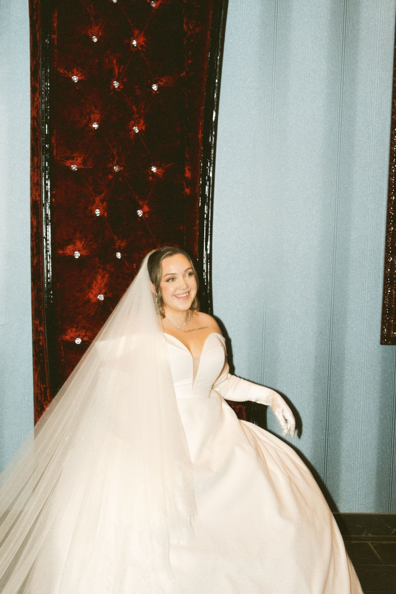 Elegant white wedding gown with flowing train photographed against decorative backdrop.