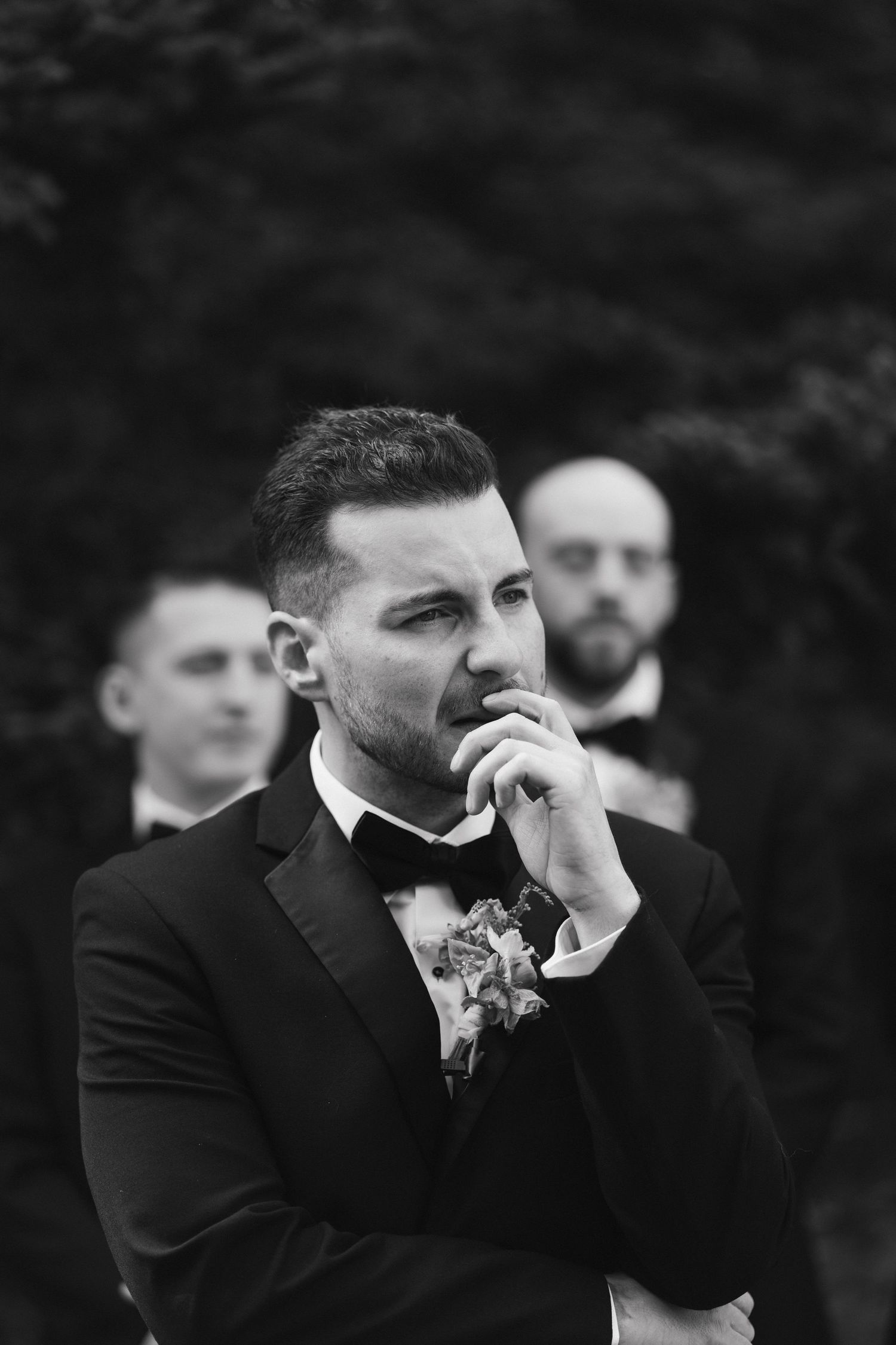 Emotional wedding moment captured in black and white as attendees react during ceremony.