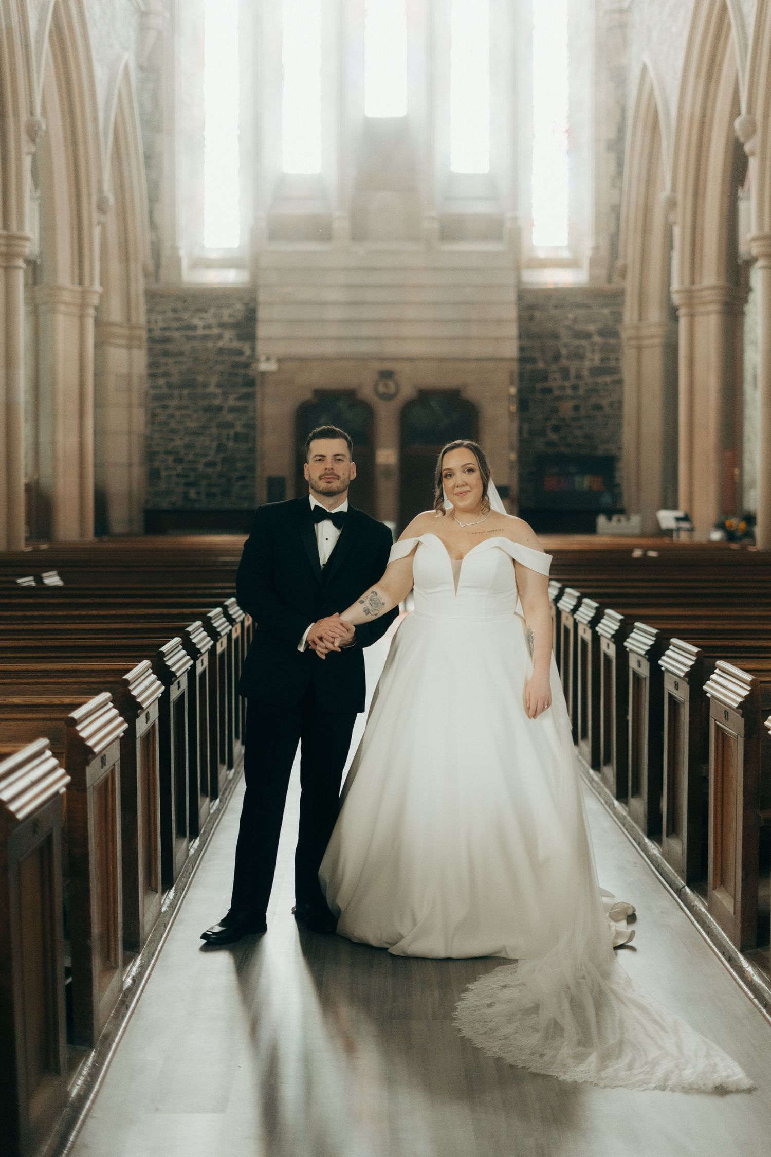 A graceful wedding scene inside a historic church with wooden pews and tall windows.