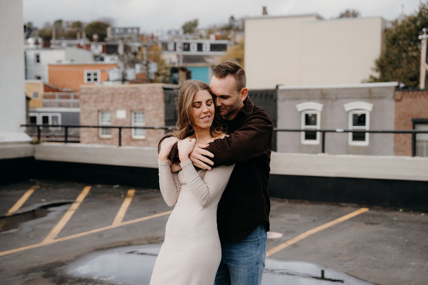 Emotional black and white moment between couple during urban rooftop photoshoot.