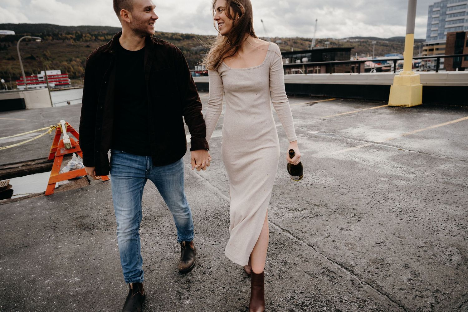 Romantic couple strolling together on a rooftop, wearing casual and formal attire.