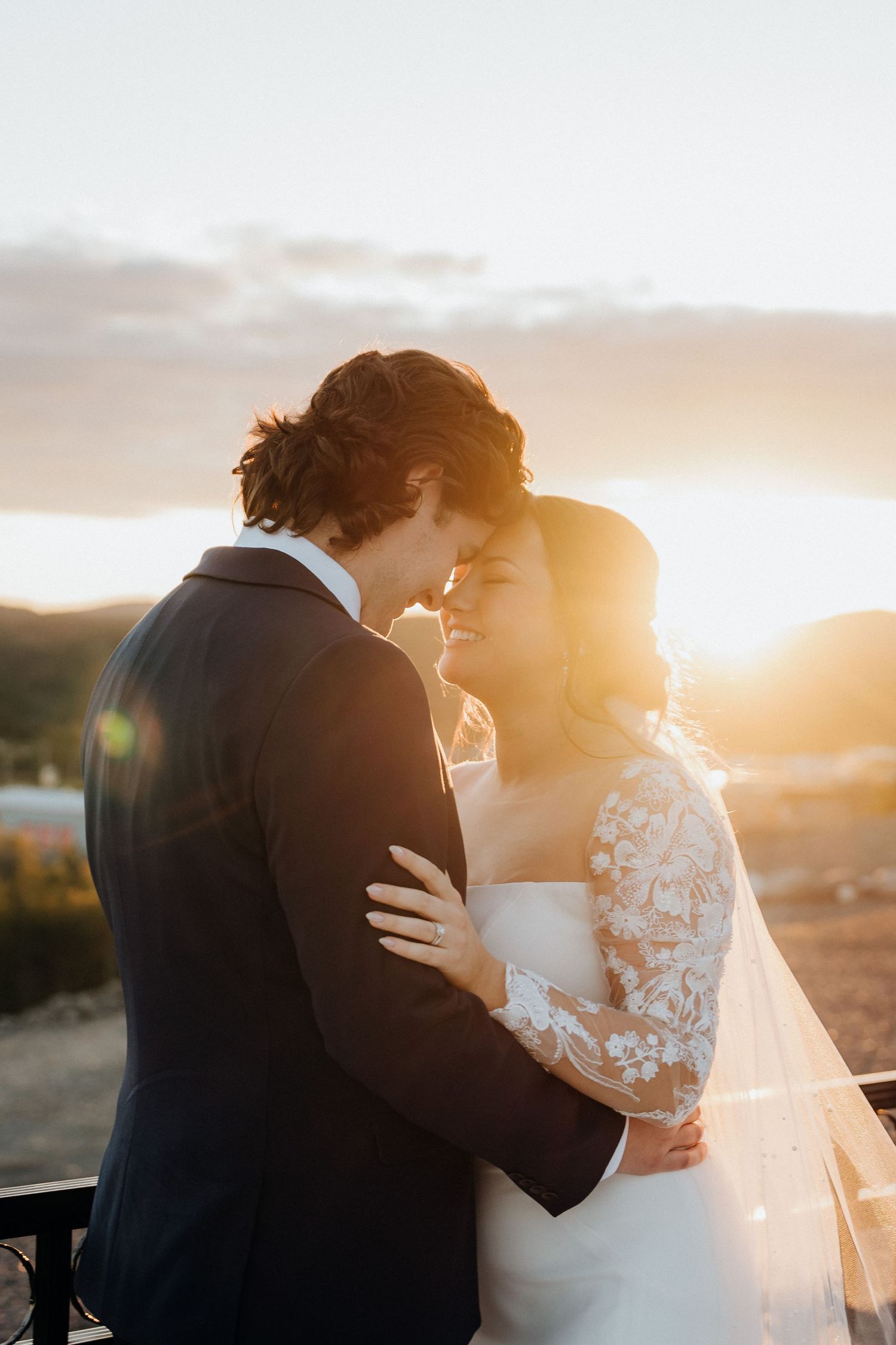 Romantic sunset portrait of newlyweds sharing an intimate moment.