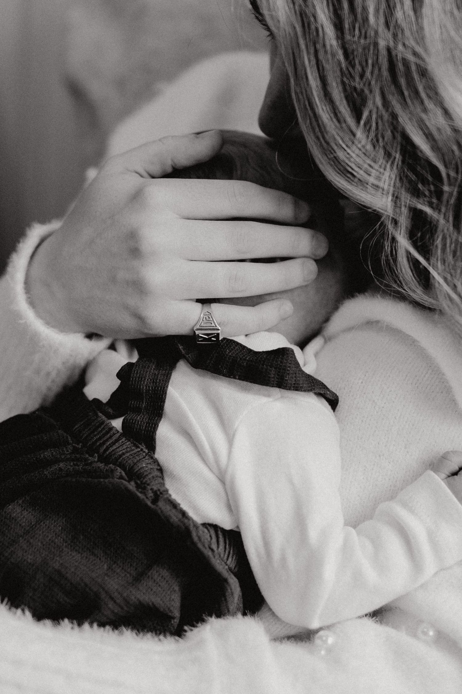 Close-up intimate moments captured in black and white showing gentle touch and connection.