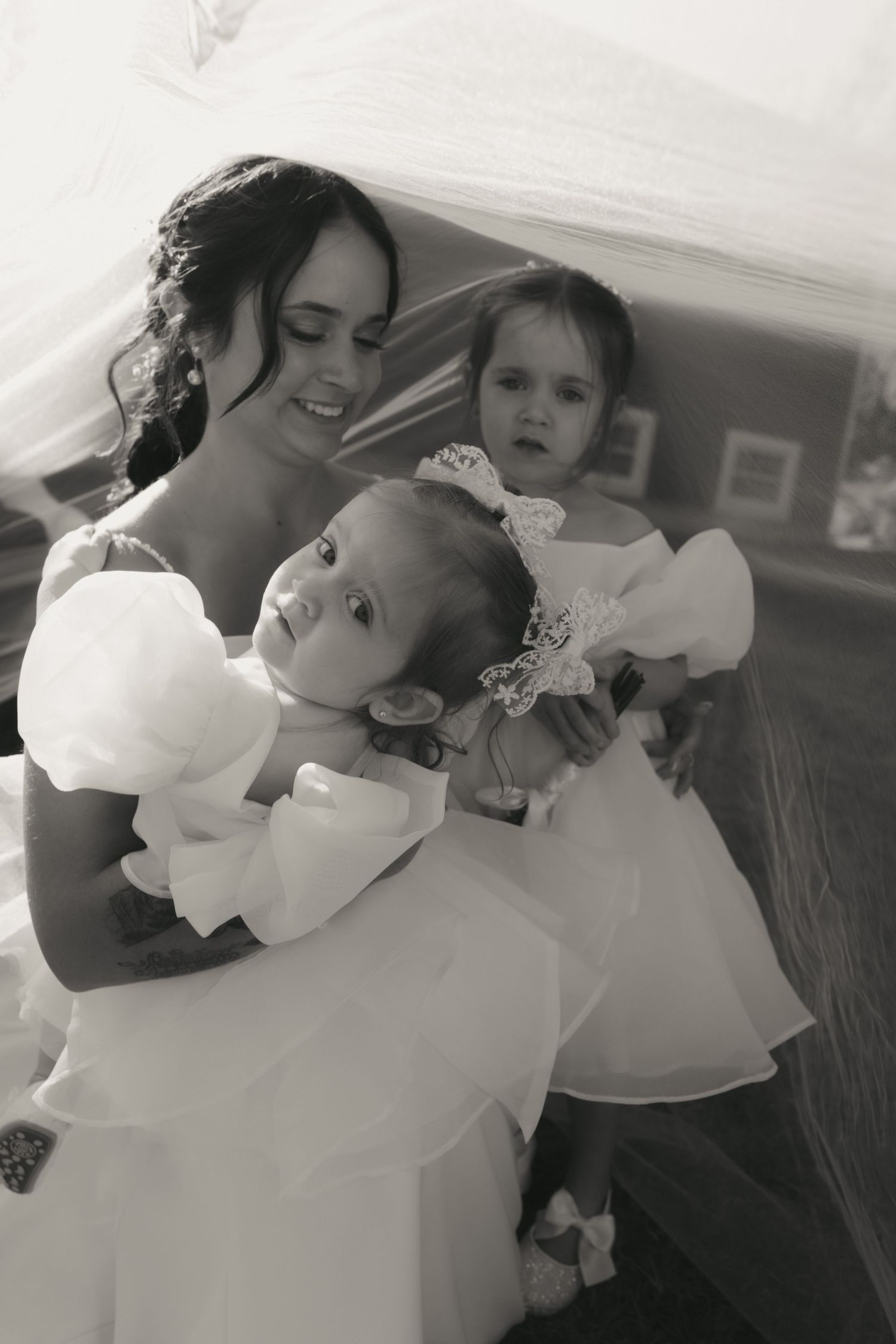 A tender black and white photo series showing intimate moments of affection and embraces in matching white outfits.