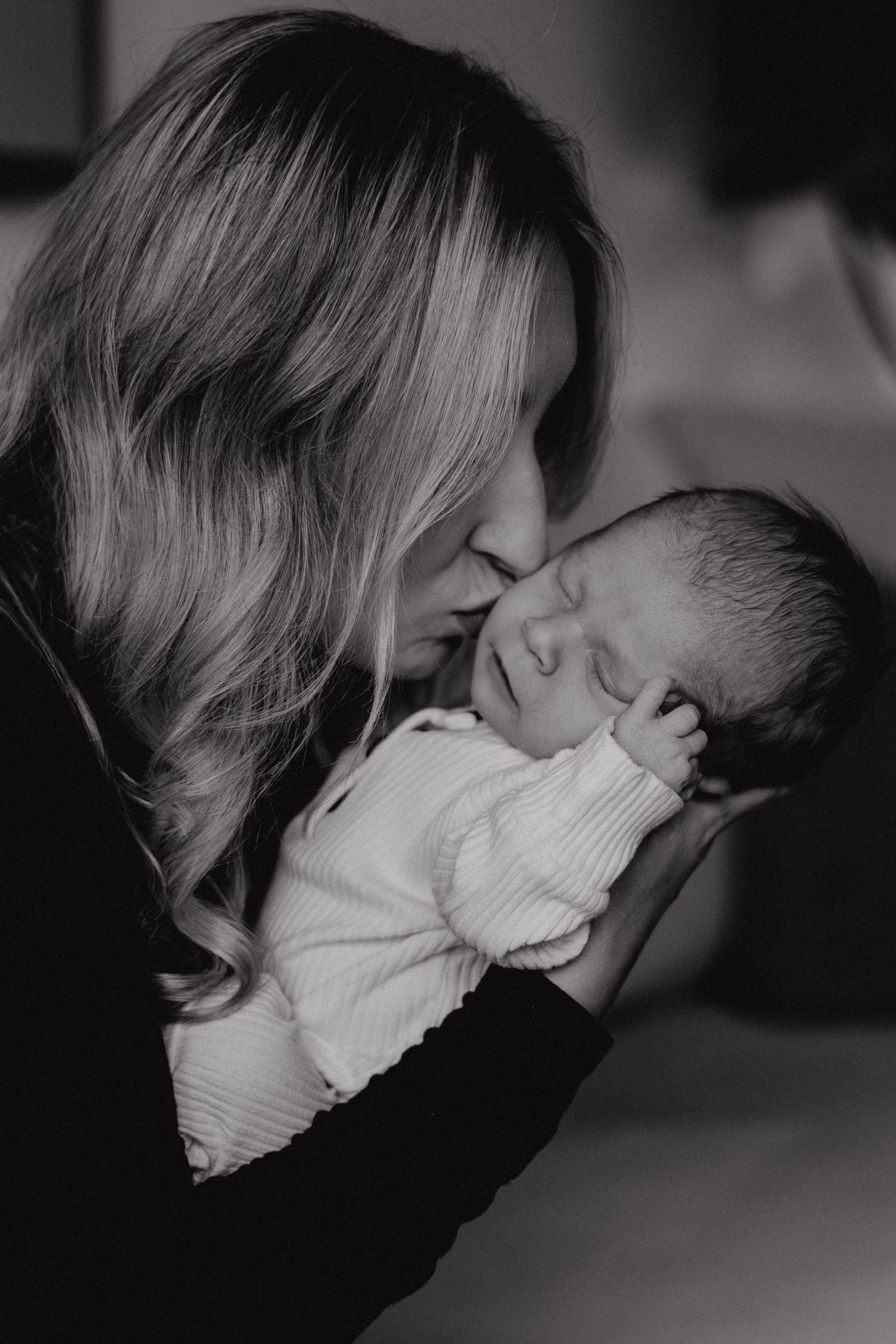 Atmospheric black and white photo capturing nurturing moments with a baby.