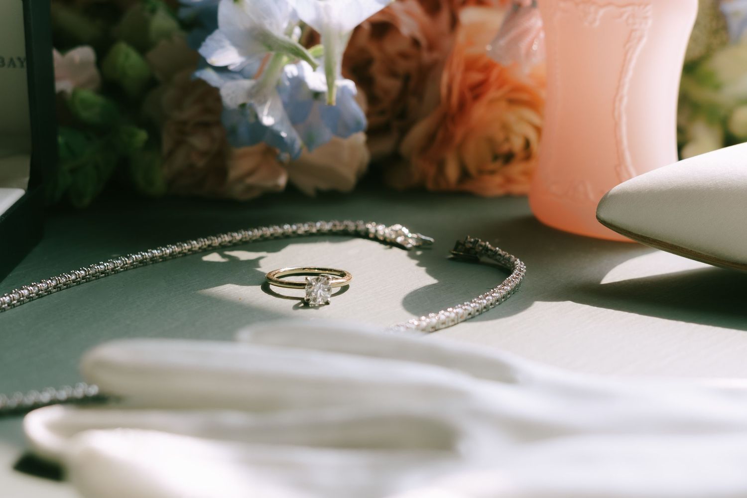 White pearls and delicate jewelry displayed on a soft surface in natural light.