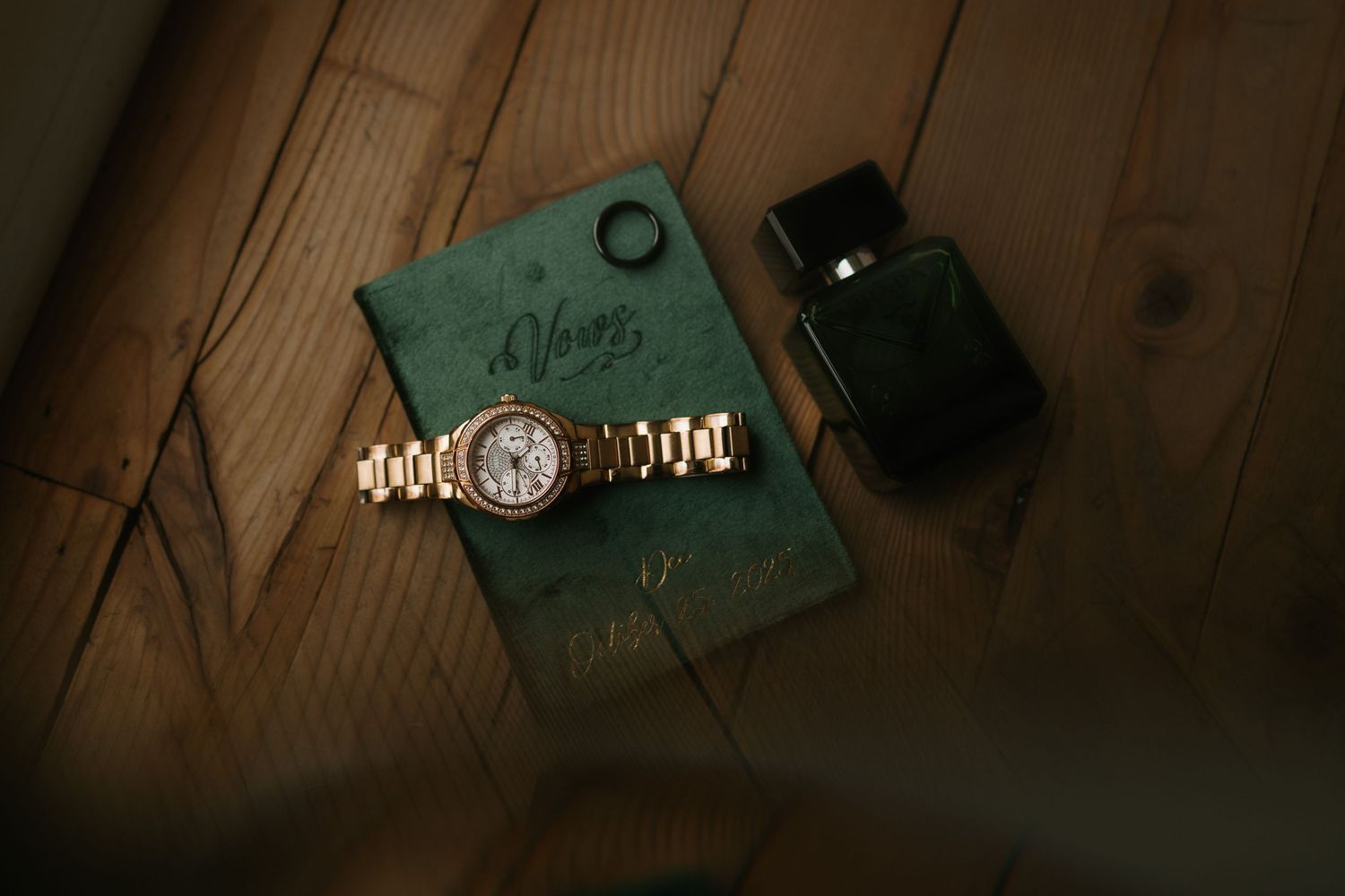 A collection of vintage items including a wristwatch, old photographs, and paper documents arranged on a wooden surface.