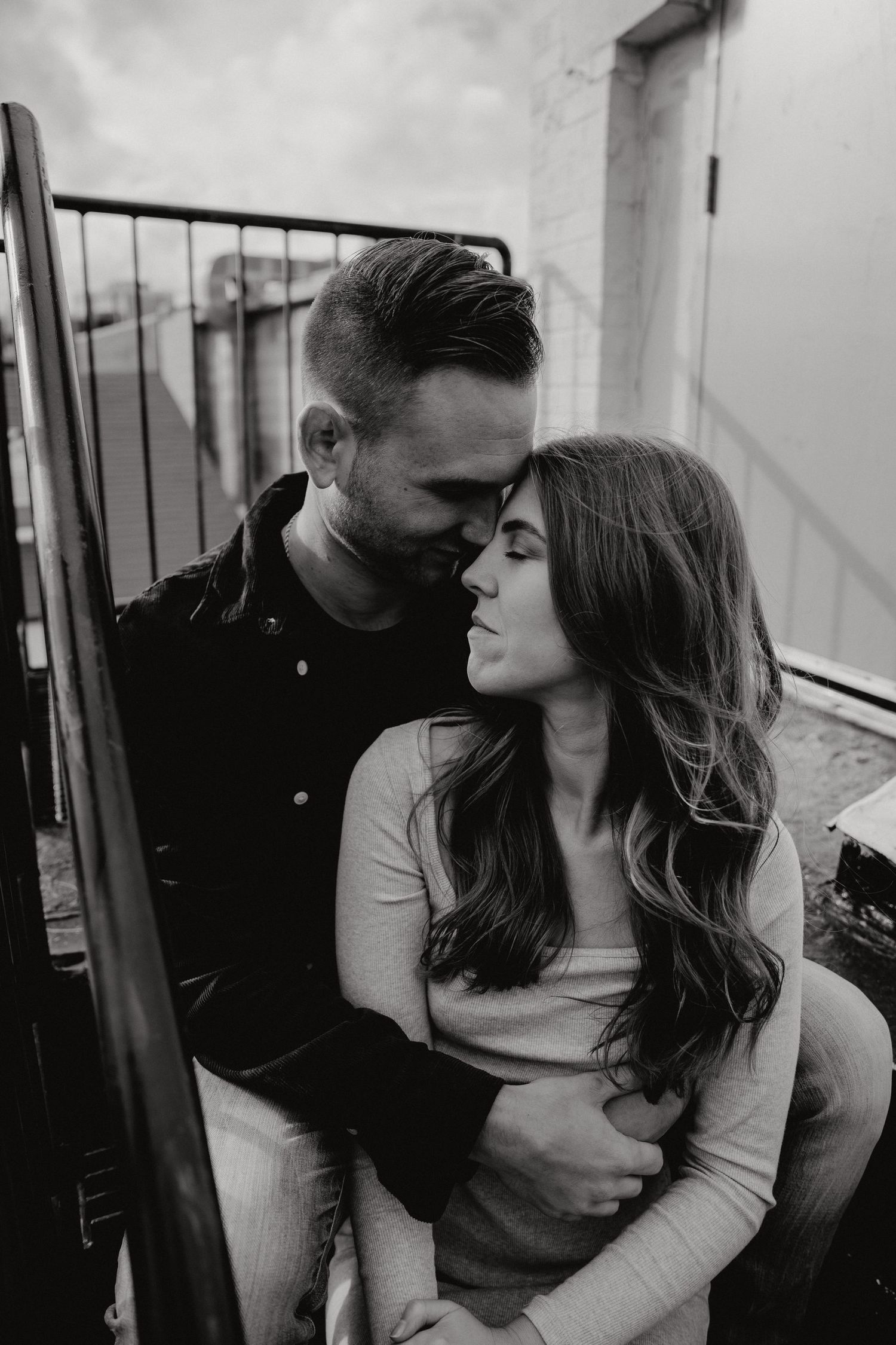 Romantic black and white portraits of couple on urban rooftop location.