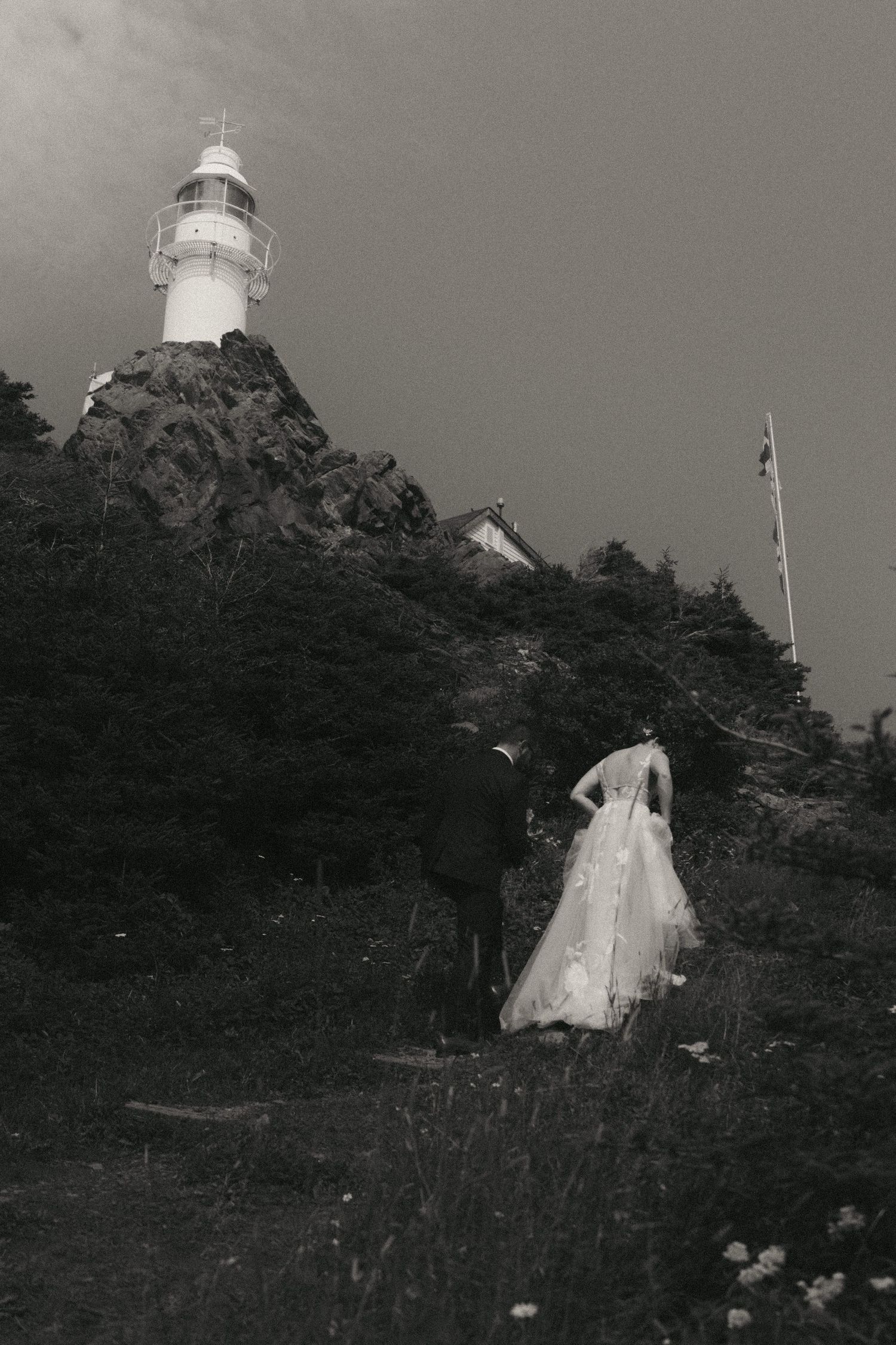 A series of black and white photographs showing a lighthouse on a steep hillside against a dark sky.