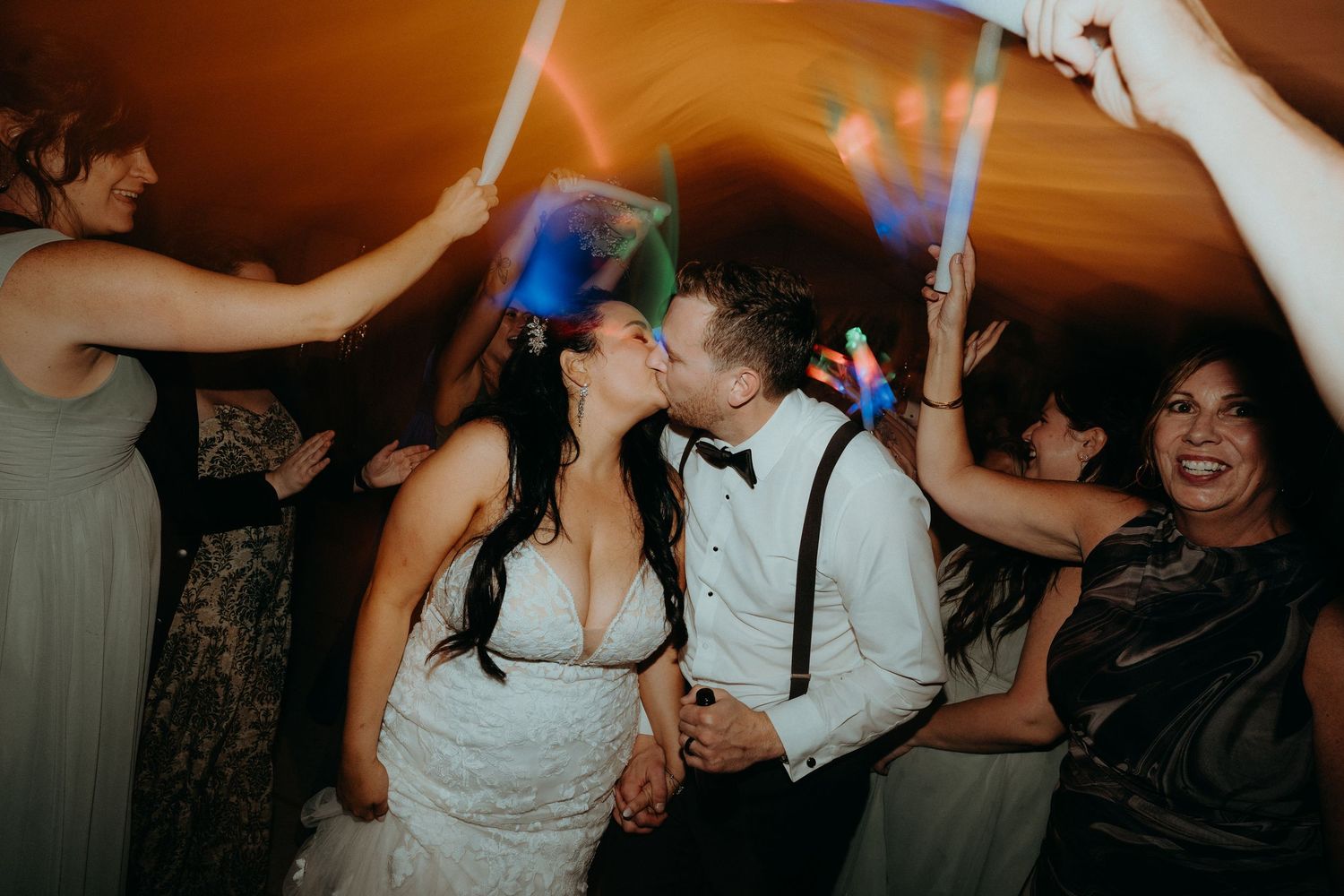 Lively dance floor celebration with guests during wedding reception.