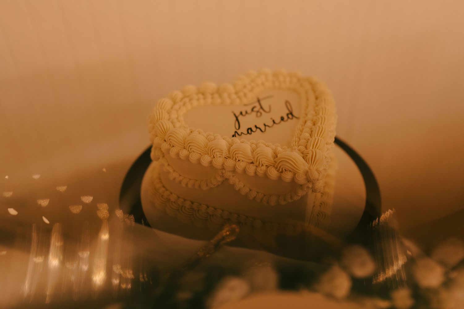 A rustic wedding ring rests on a textured surface in warm sepia lighting.