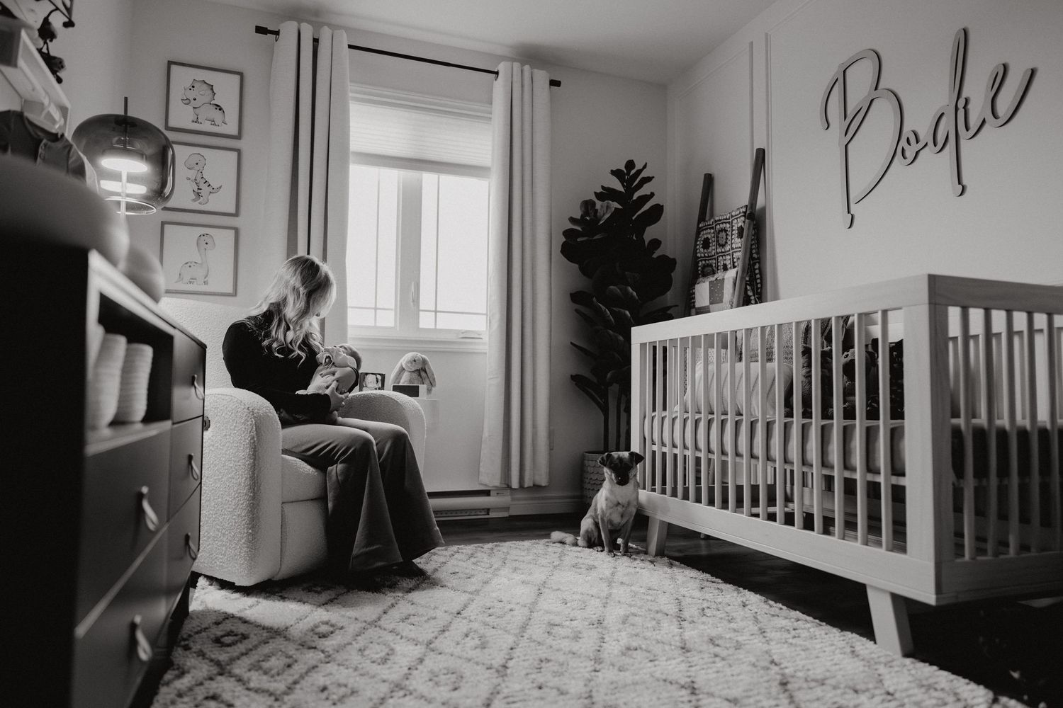 Nursery room interior with white crib, geometric rug, and modern pendant light fixture.