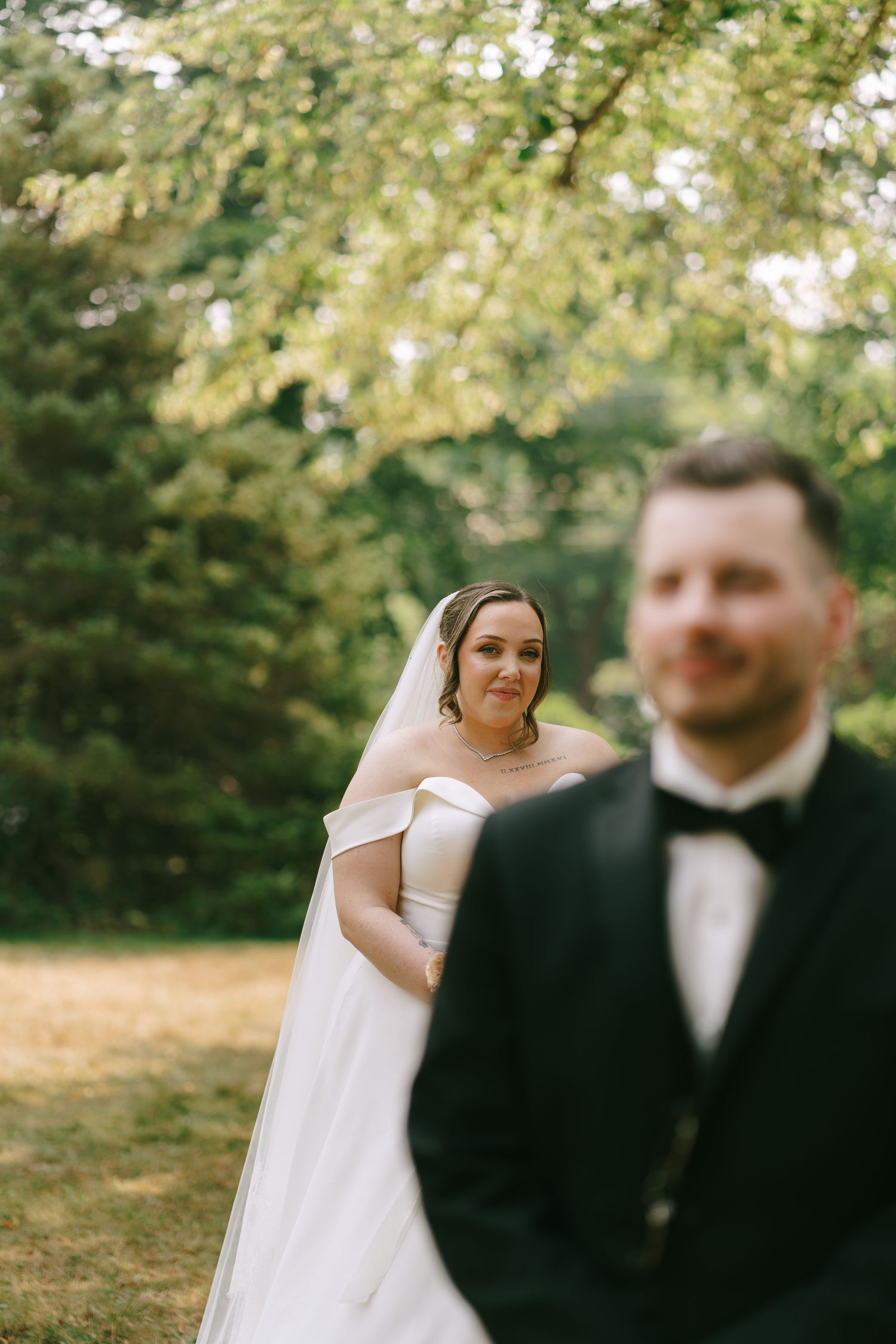 Candid wedding portraits taken under trees with natural sunlight filtering through.