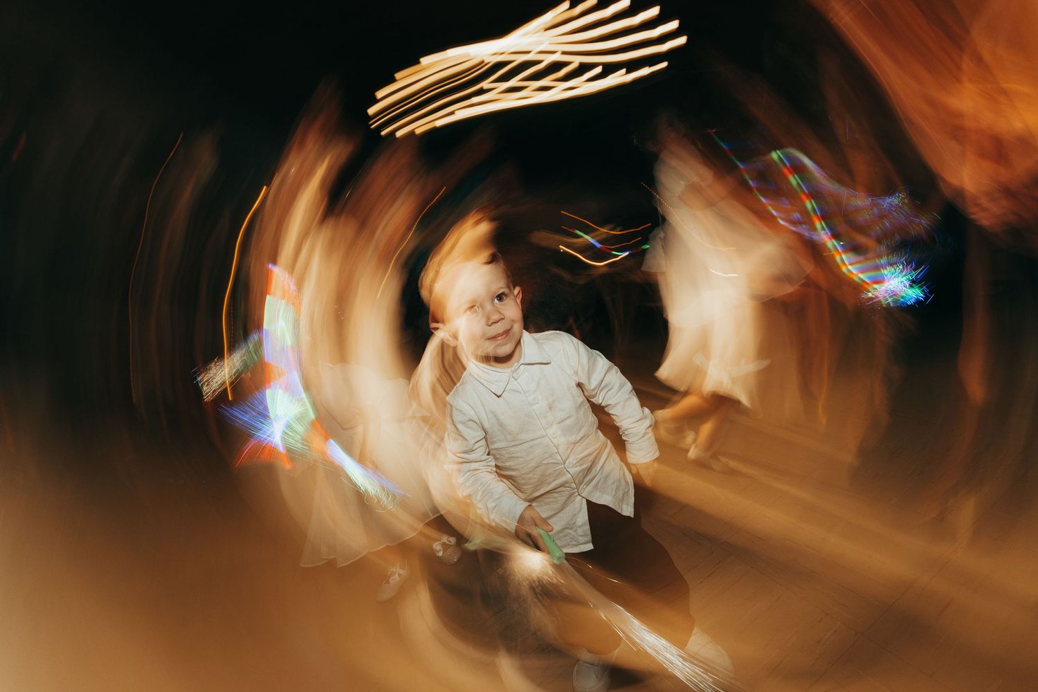 Long exposure photo shows streaks of light and motion blur creating an abstract pattern in warm tones.