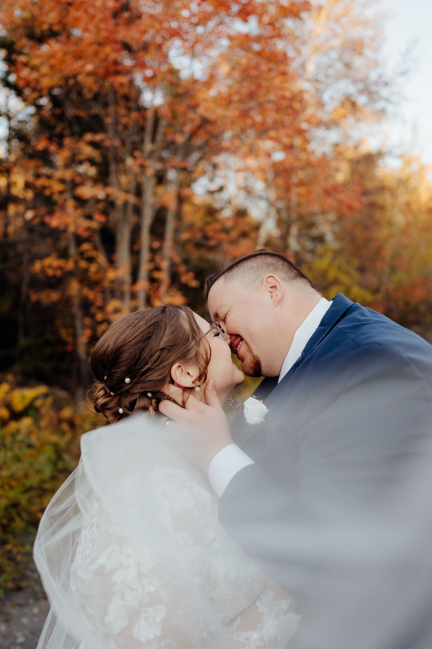 Romantic autumn wedding scene with orange and gold leaves creating a natural backdrop.