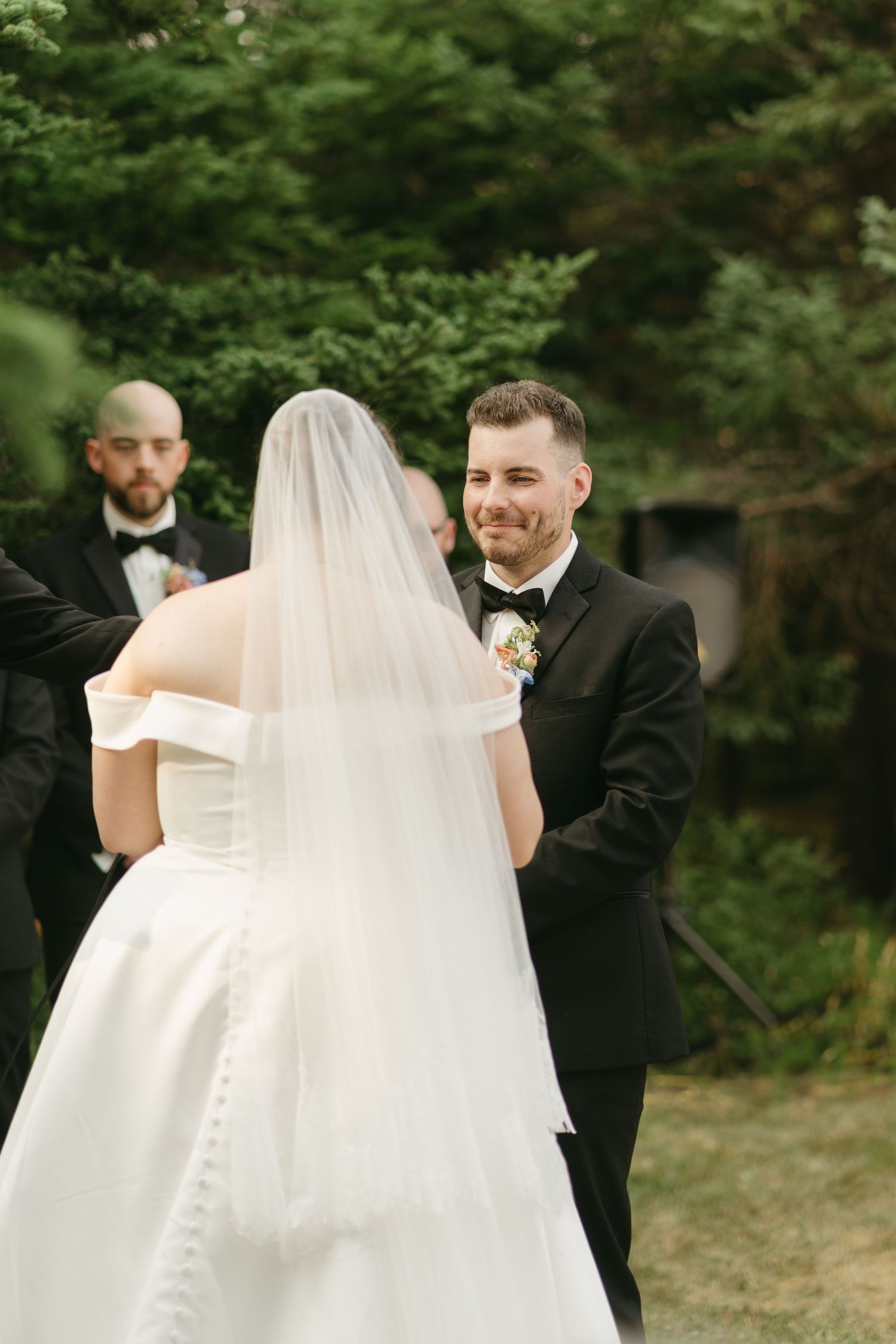 Intimate wedding moment captured between couple with flowing white veil detail.
