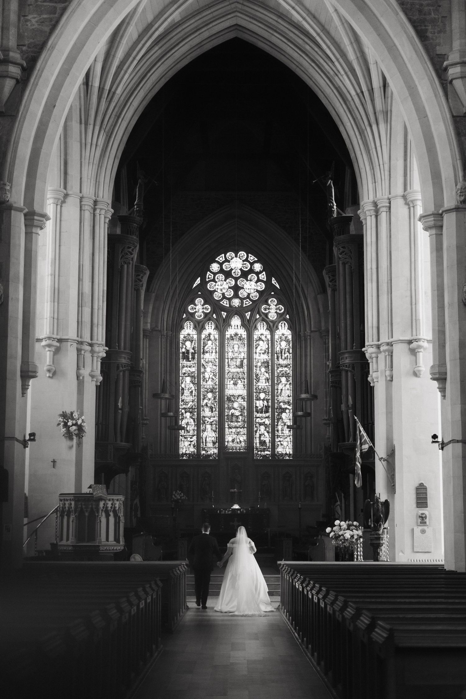 Gothic church interior with stunning arched windows and vaulted ceilings in black and white.