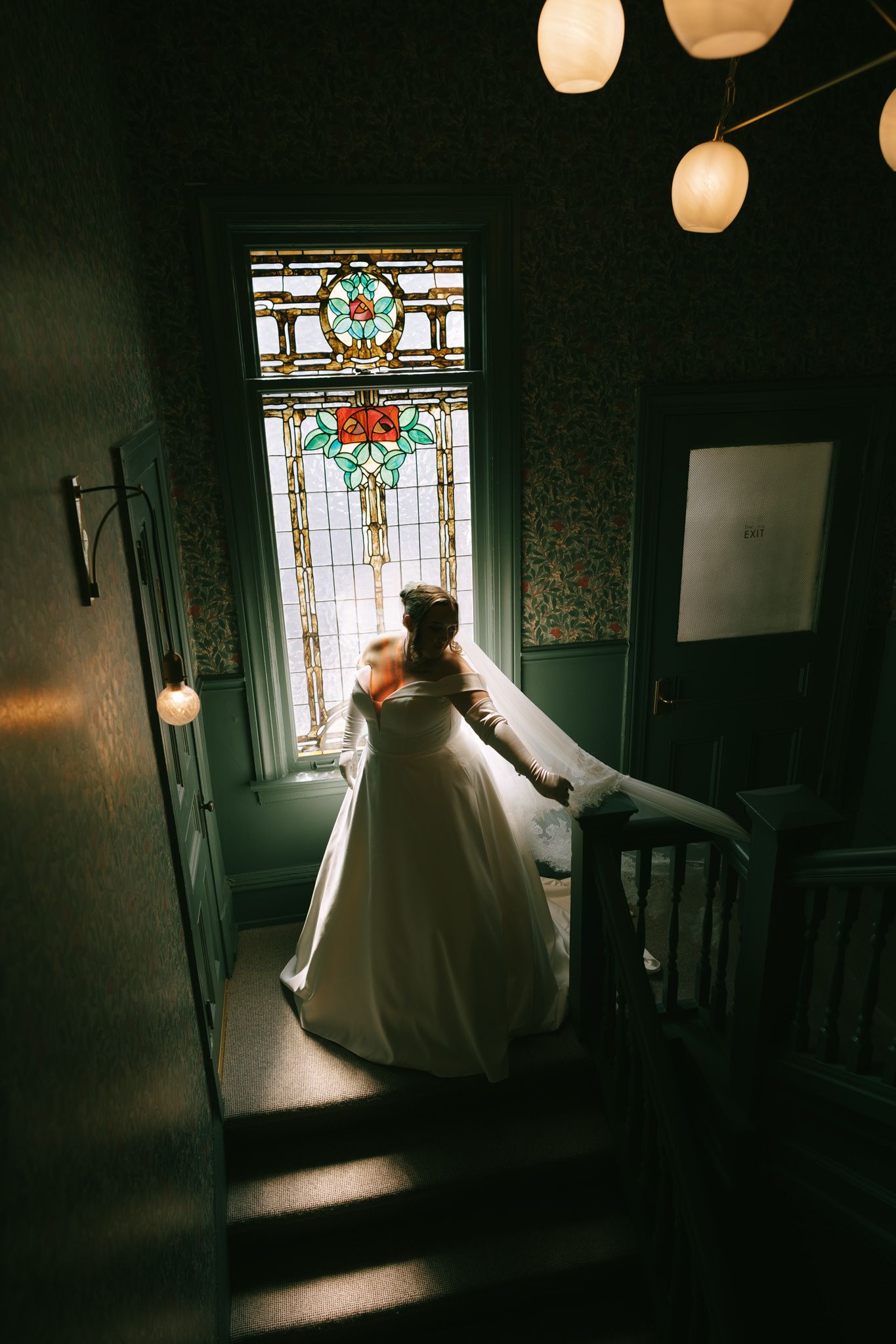 Moody bridal portrait in vintage room with stained glass windows and paper lanterns.