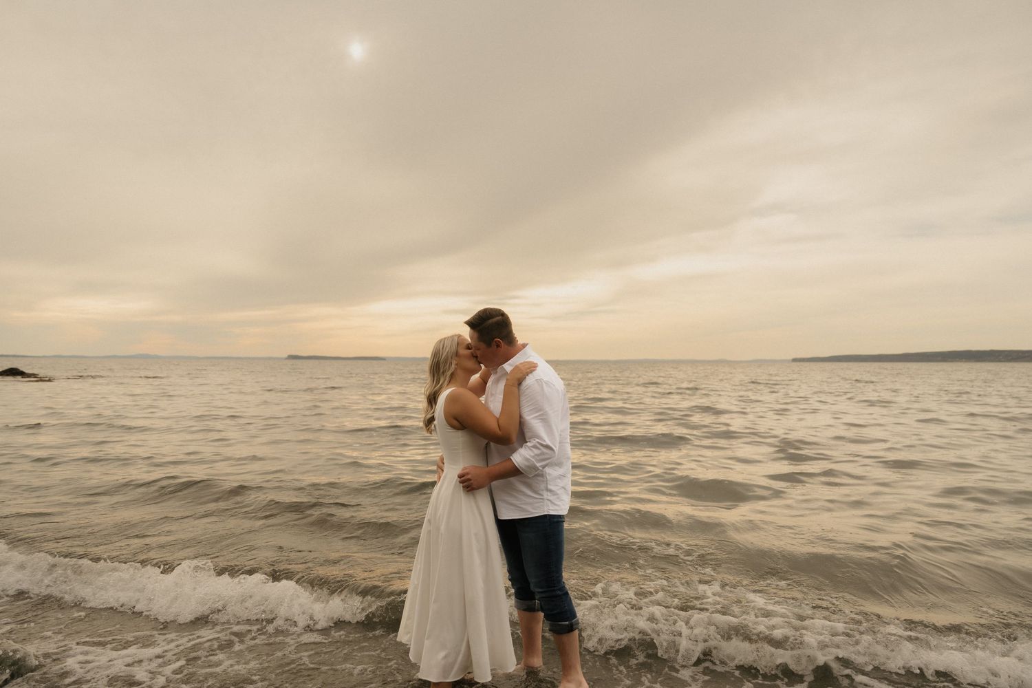 A romantic couple embraces on a beach at sunset with multiple photos showing different angles of the moment.