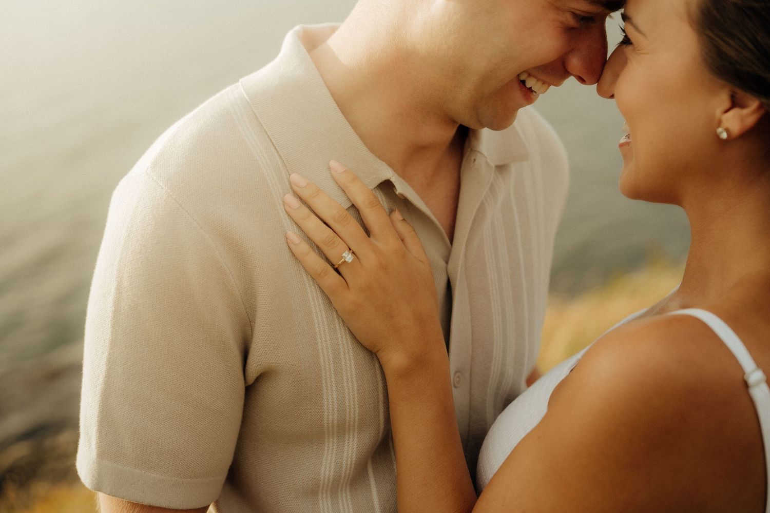 Romantic couple in casual white clothing share intimate moments during golden hour photography session.